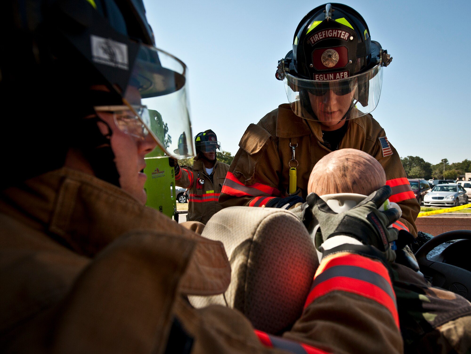 Staff Sgt. Todd Lawrence and Justin Heinen, Eglin Air Force Base firefighters, slowly remove a simulated victim from his vehicle during their car extrication demonstration at the Base Exchange Oct. 12. The firefighters demonstrated how quickly they can open up a car to free a trapped victim of an accident.  (U.S. Air Force photo/Samuel King Jr.)