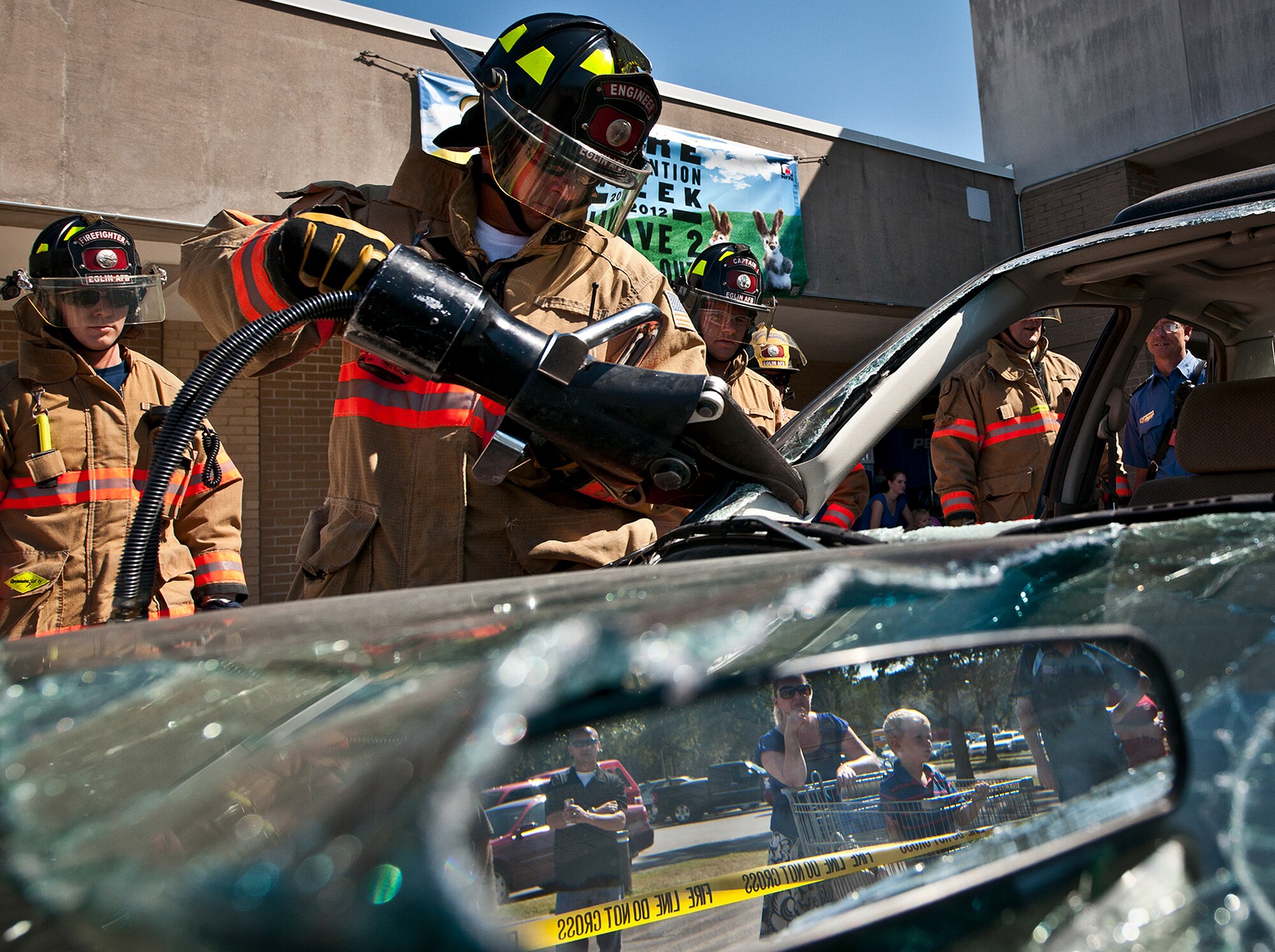 Michael Barrow, a firefighter with the 96th Civil Engineer Group, uses a cutting tool to remove the roof of a car during a car extrication demonstration at the Eglin’s Base Exchange Oct. 12. The firefighters demonstrated how quickly they can open up a car to free a trapped victim of an accident.  (U.S. Air Force photo/Samuel King Jr.)