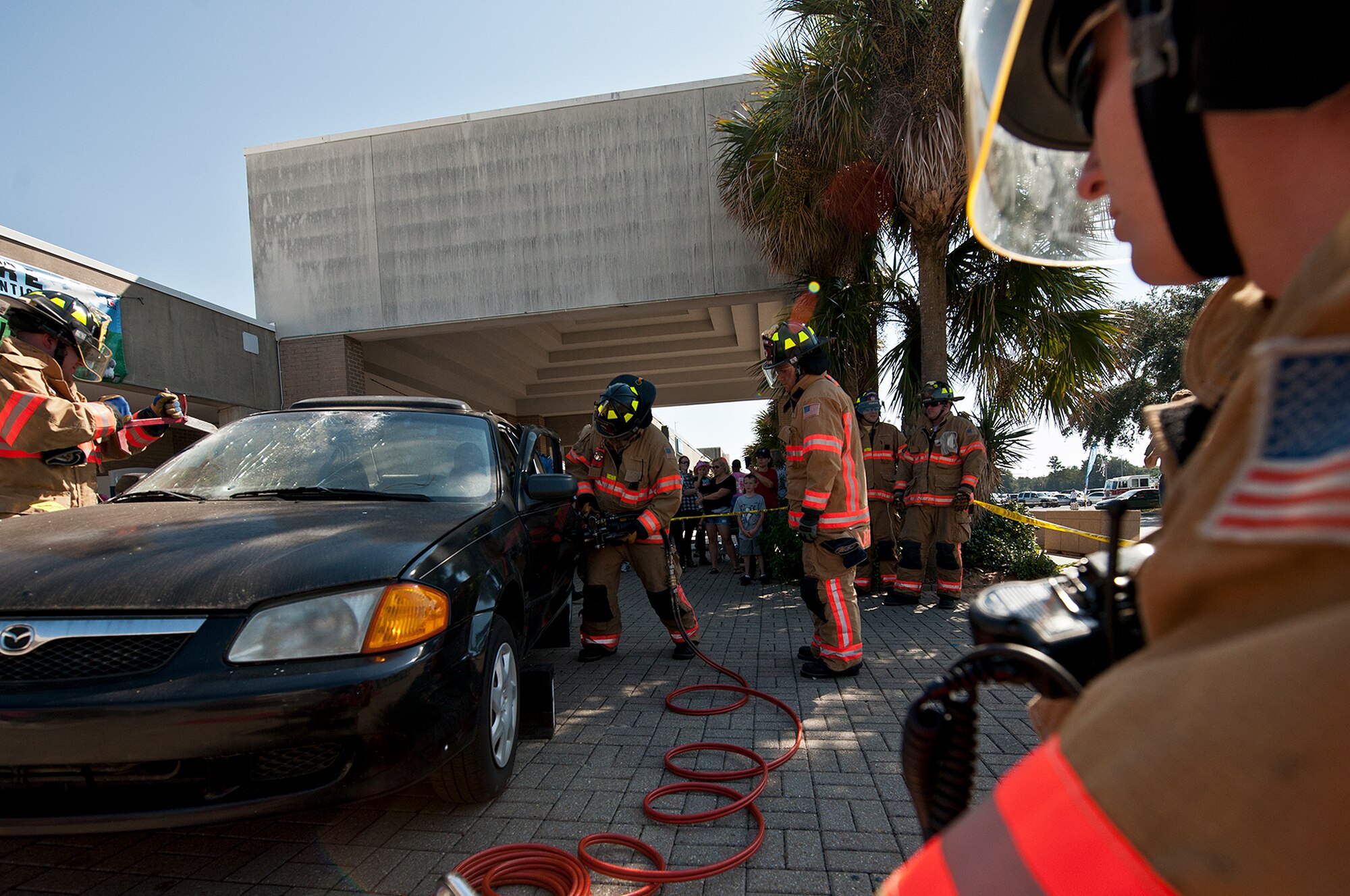 Eglin Air Force Base firefighters begin opening up a car during their car extrication demonstration at the Base Exchange Oct. 12. The firefighters demonstrated how quickly they can open up a car to free a trapped victim of an accident.  (U.S. Air Force photo/Samuel King Jr.)
