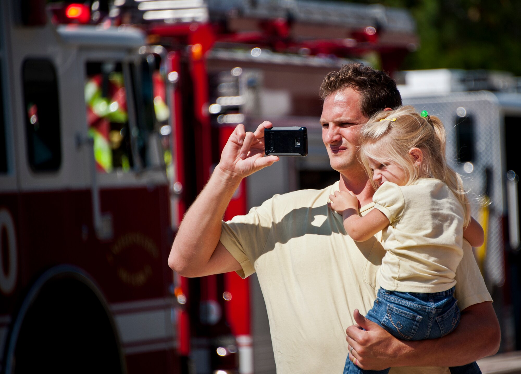 A father and daughter watch a car extrication demonstration by the Eglin Air Force Base firefighters at the Base Exchange Oct. 12. The firefighters demonstrated how quickly they can open up a car to free a trapped victim of an accident.  (U.S. Air Force photo/Samuel King Jr.)