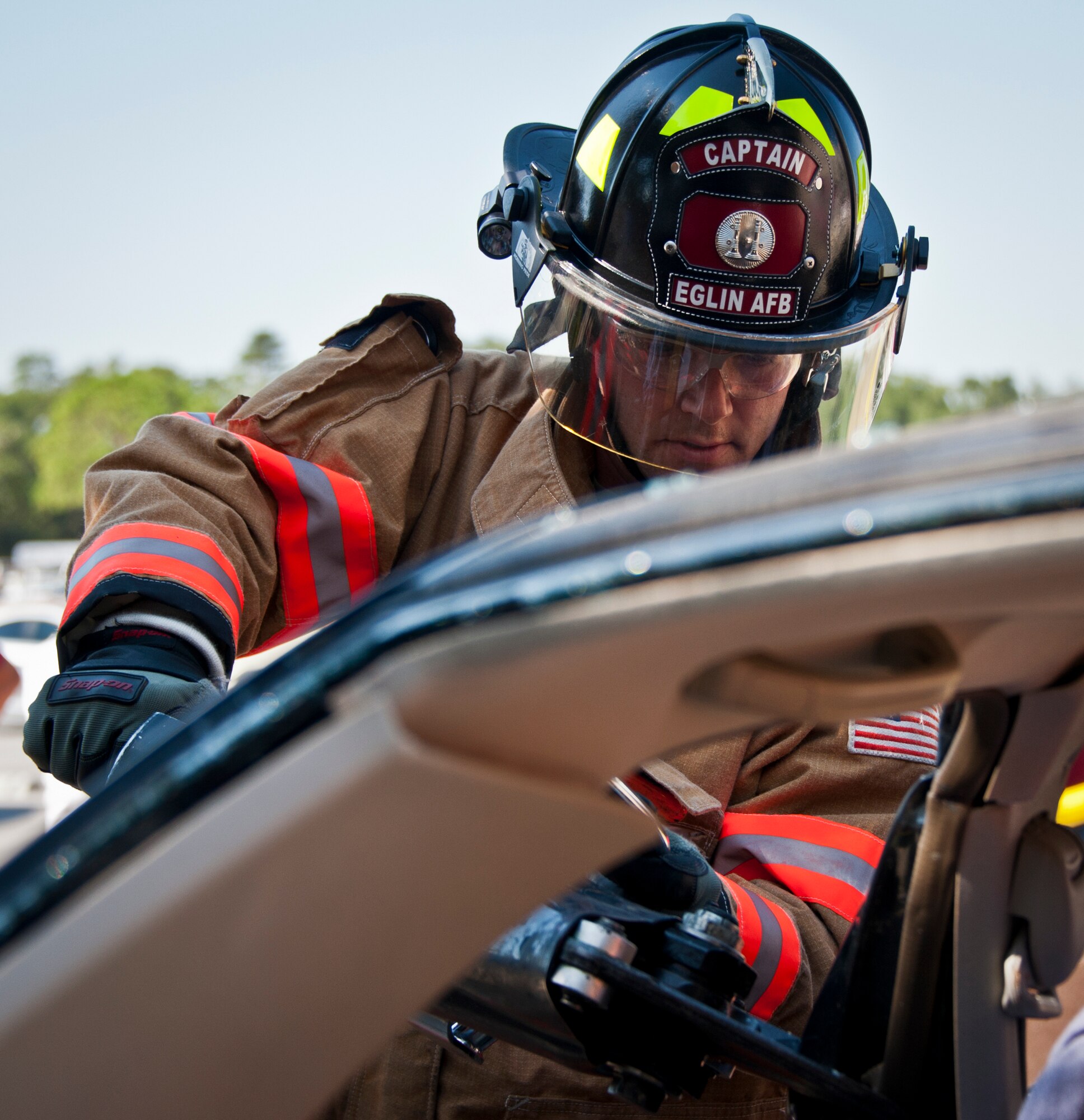Staff Sgt. Todd Lawrence, a firefighter with the 96th Civil Engineer Group, uses a prying tool to open up the doors of a car during a car extrication demonstration at the Eglin’s Base Exchange Oct. 12. The firefighters demonstrated how quickly they can open up a car to free a trapped victim of an accident.  (U.S. Air Force photo/Samuel King Jr.)
