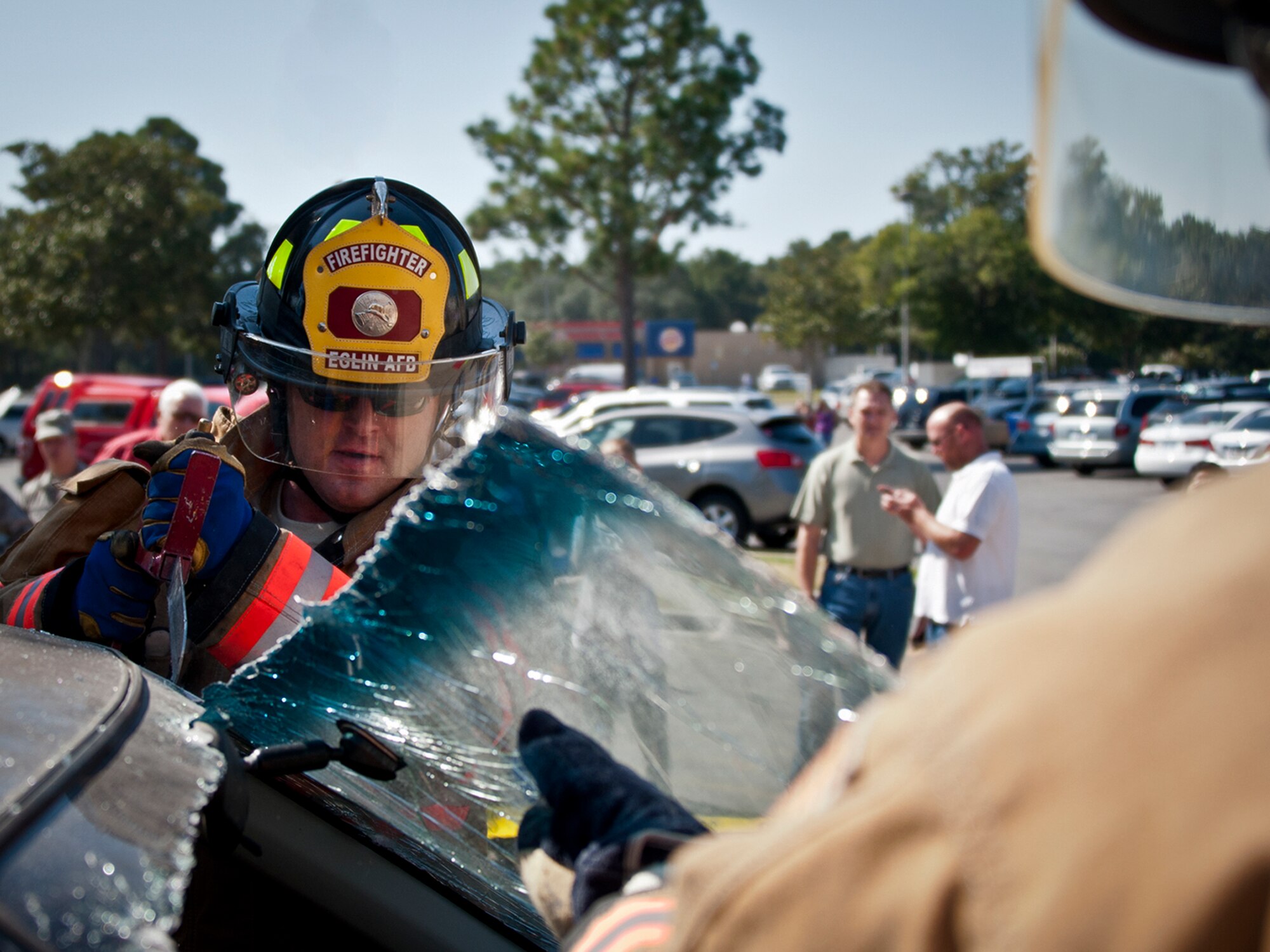 Airman 1st Class Joshua Wilson, a firefighter with the 96th Civil Engineer Group, cuts out the windshield of a car during a car extrication demonstration at the Eglin’s Base Exchange Oct. 12. The firefighters demonstrated how quickly they can open up a car to free a trapped victim of an accident.  (U.S. Air Force photo/Samuel King Jr.)