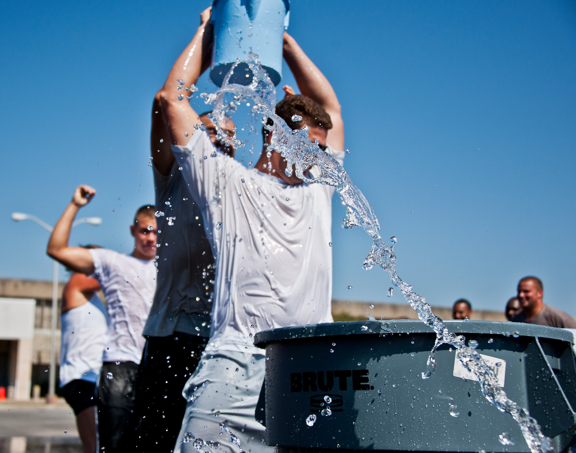 A string of water slings out as Team Eglin Airmen move a bucket of water over their heads during the annual fire muster challenge that concluded fire prevention week at Eglin Air Force Base, Fla., Oct. 12.  The challenge included a ladder and hose carry, fire engine pull, and water relay. (U.S. Air Force photo/Samuel King Jr.)