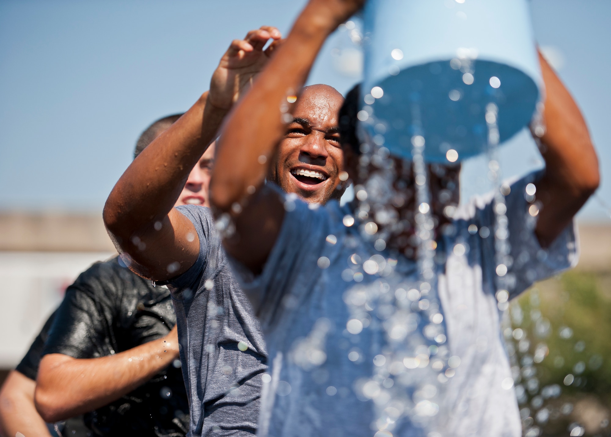An Airman watches as his teammate raises the bucket over her head during the annual fire muster challenge that concluded fire prevention week at Eglin Air Force Base, Fla., Oct. 12.  Teams competed in the challenge that included a ladder and hose carry, fire engine pull, and water relay. (U.S. Air Force photo/Samuel King Jr.)