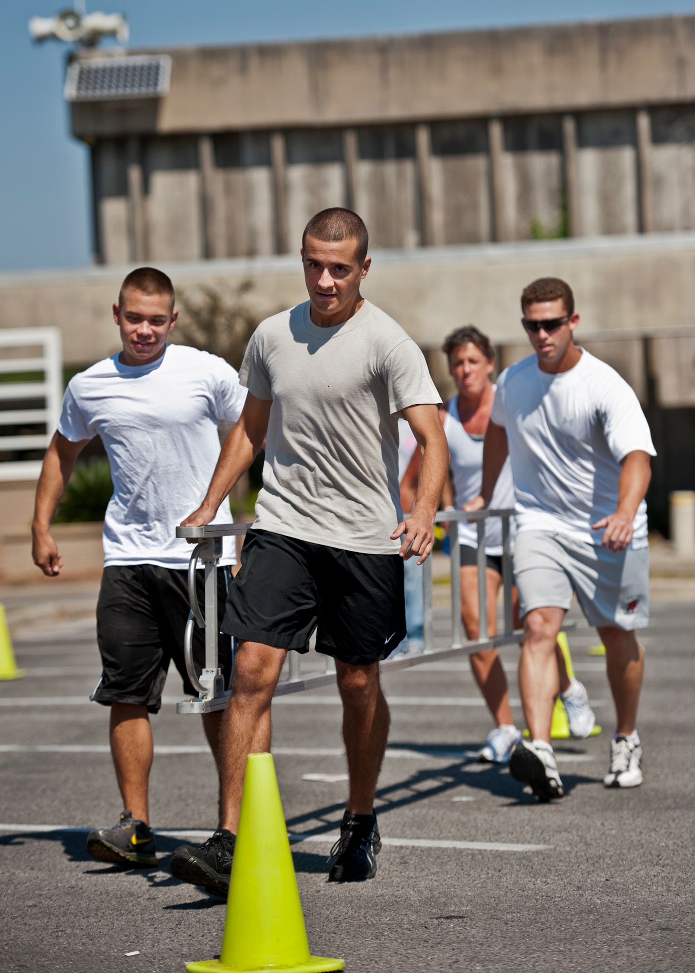 A team of four carries a ladder around the cones during the annual fire muster challenge that concluded fire prevention week at Eglin Air Force Base, Fla., Oct. 12.  Teams competed in the challenge that included a team ladder carry, fire hose roll up, victim-carry and water relay.  (U.S. Air Force photo/Samuel King Jr.)