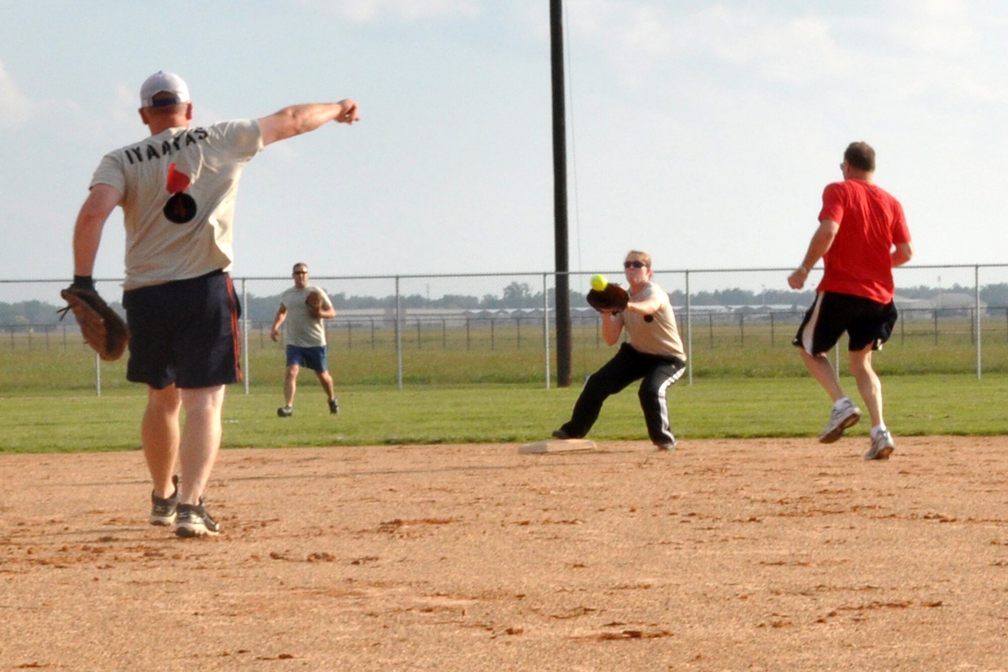 Leo Kamphaus tries to beat the throw to Laura McMillen during a softball game held at Barksdale Air Force Base, La., Oct. 13, 2012.  McMillen tagged Kamphaus out on the force run from first base.  A large group of Airmen from the 307th Maintenance Squadron took part in the friendly competition. (U.S. Air Force photo by Staff Sgt. Ted Daigle/Released)