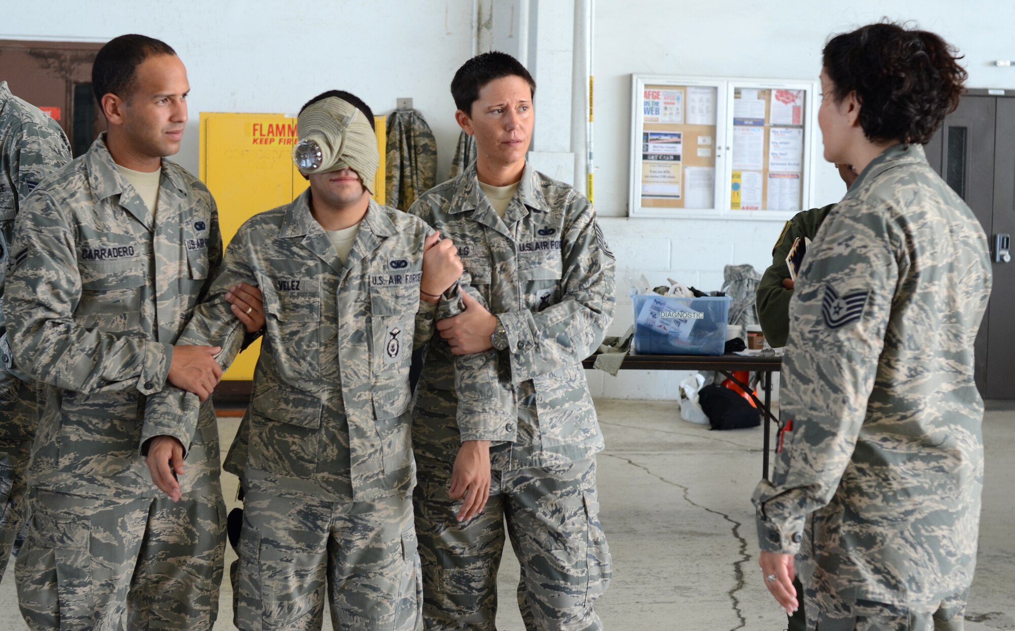 920th Rescue Wing Security Forces, Airman 1st Class Efrain Carradero and Tech. Sgt. Kelly Wills (far right) lead Senior Airman Jose Velez (middle), after medically "treating" him for an eye injury during Self Aid, Buddy Care training here. Reserve Airmen continue their training for a Combined Unit Inspection that test the skills and preparedness of the Reservists during scenarios that mimic what they may find while deployed in a combat environment. They will have their deployment readiness tested with an official grade by an inspection team during the final phase of the Inspection slated for April 2013. (U.S. Air Force photo/2nd Lt. Leslie Forshaw)