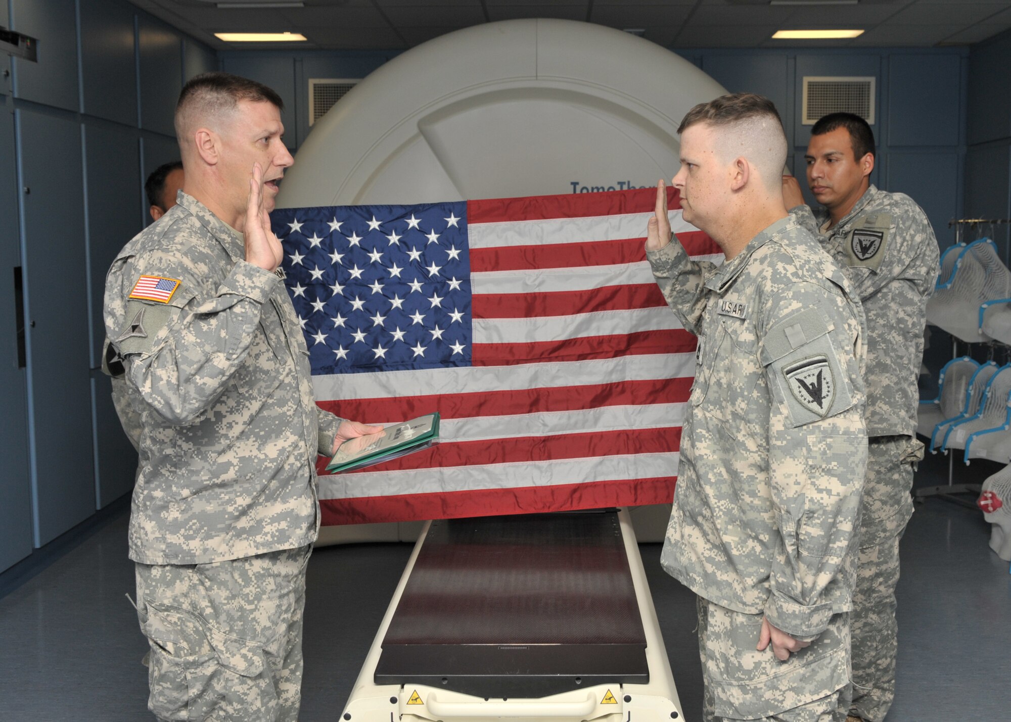 CAMBRIDGE, United Kingdom - U.S. Army Sgt.1st Class Jason Stanford takes the oath of enlistment from U.S. Army Col. Matthew Glunz, United States European Command Joint Intelligence Operations Center - Europe Analytic Center commander, as he re-enlists in front of a radiology machine at Addenbrookes Hospital Cambridge, United Kingdom, Oct. 11. (U.S. Air Force photo by Staff Sgt. Javier Cruz)