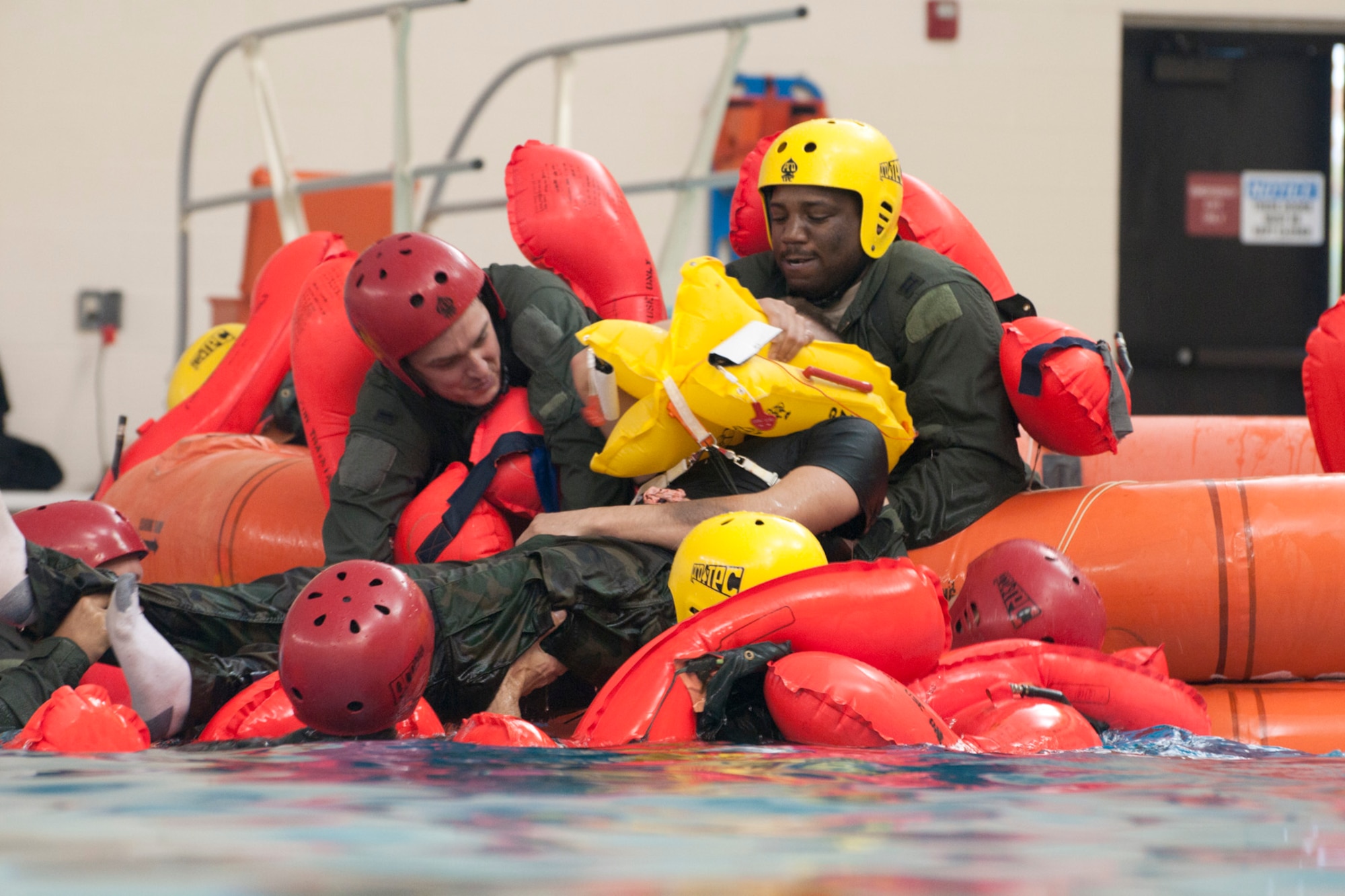 1st Lt. Will Rexer, left, and Capt. Donald Davenport, both pilots with the 171st Air Refueling Squadron, work together to pull an “injured” Airman out of the water during survival training in the pool of L’Anse Cruese North High School, near Selfridge Air National Guard Base, Mich., Oct. 16, 2012. Since Air Force air crews operate in a worldwide environment, they must train for every contingency scenario, including the possibility of a downed aircraft in an ocean or lake.  The 171st flies the KC-135 Stratotanker, which can carry approximately 50 passengers. (Air National Guard photo by TSgt. Robert Hanet)