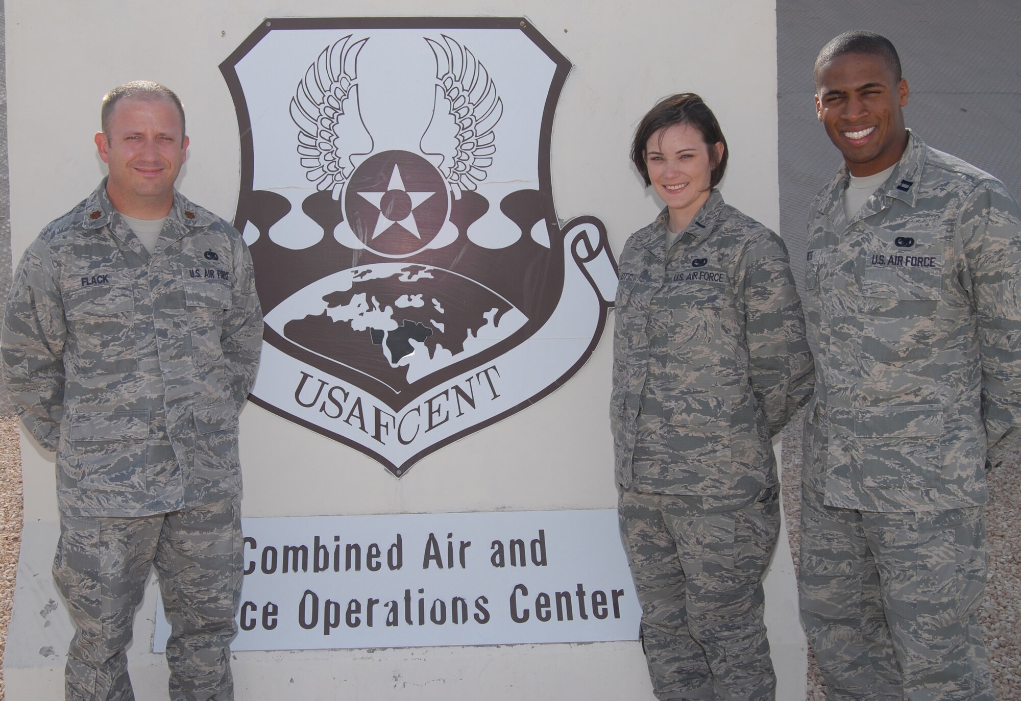 Maj. Bary Flack (left), 1st Lt. Amanda Elliott and Capt. Allen Batiste, all from the U.S. Air Forces Central Command Air Mobility Division airlift control team, pose for a group photo Oct. 15, 2012 in front of the Combined Air and Space Operations Center, Southwest Asia. In addition to moving intra-theater passengers in standard rotational movements, AMD teams also coordinate aeromedical evacuation missions, refueling operations, cargo transportation, and airdrops. (U.S. Air Force photo/Tech. Sgt. Mike Andriacco)