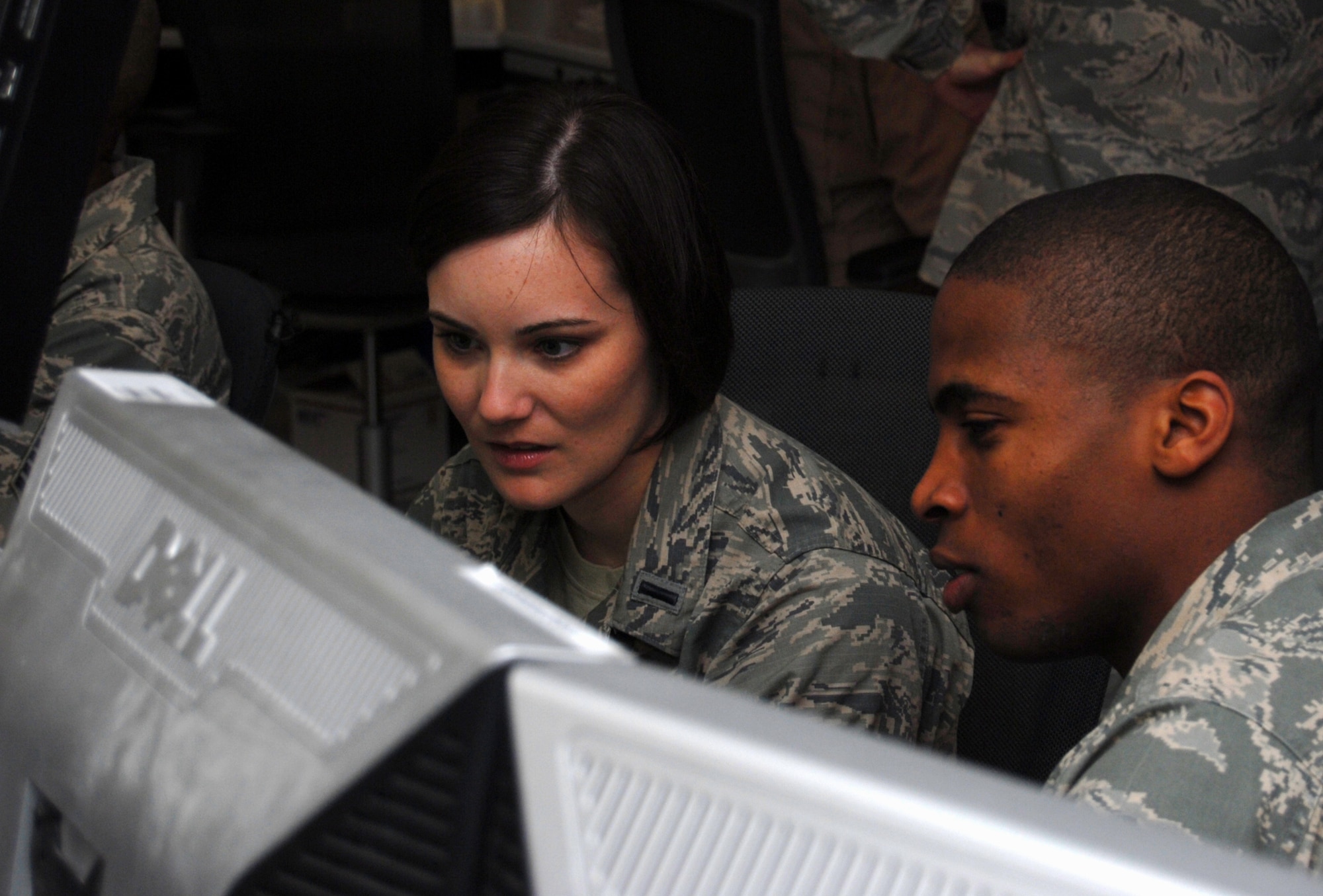 1st Lt. Amanda Elliott and Capt. Allen Batiste, both from the U.S. Air Forces Central Command Air Mobility Division airlift control team in Southwest Asia, review movement plans for aircraft Oct. 15, 2012, at the Combined Air and Space Operations Center AMD work section. While aircrews and aircraft do the “heavy lifting” of transporting passengers from one point to another, AMD plans and coordinates each movement within the theater, ensuring the success of all mobility operations. (U.S. Air Force photo/Tech. Sgt. Mike Andriacco)