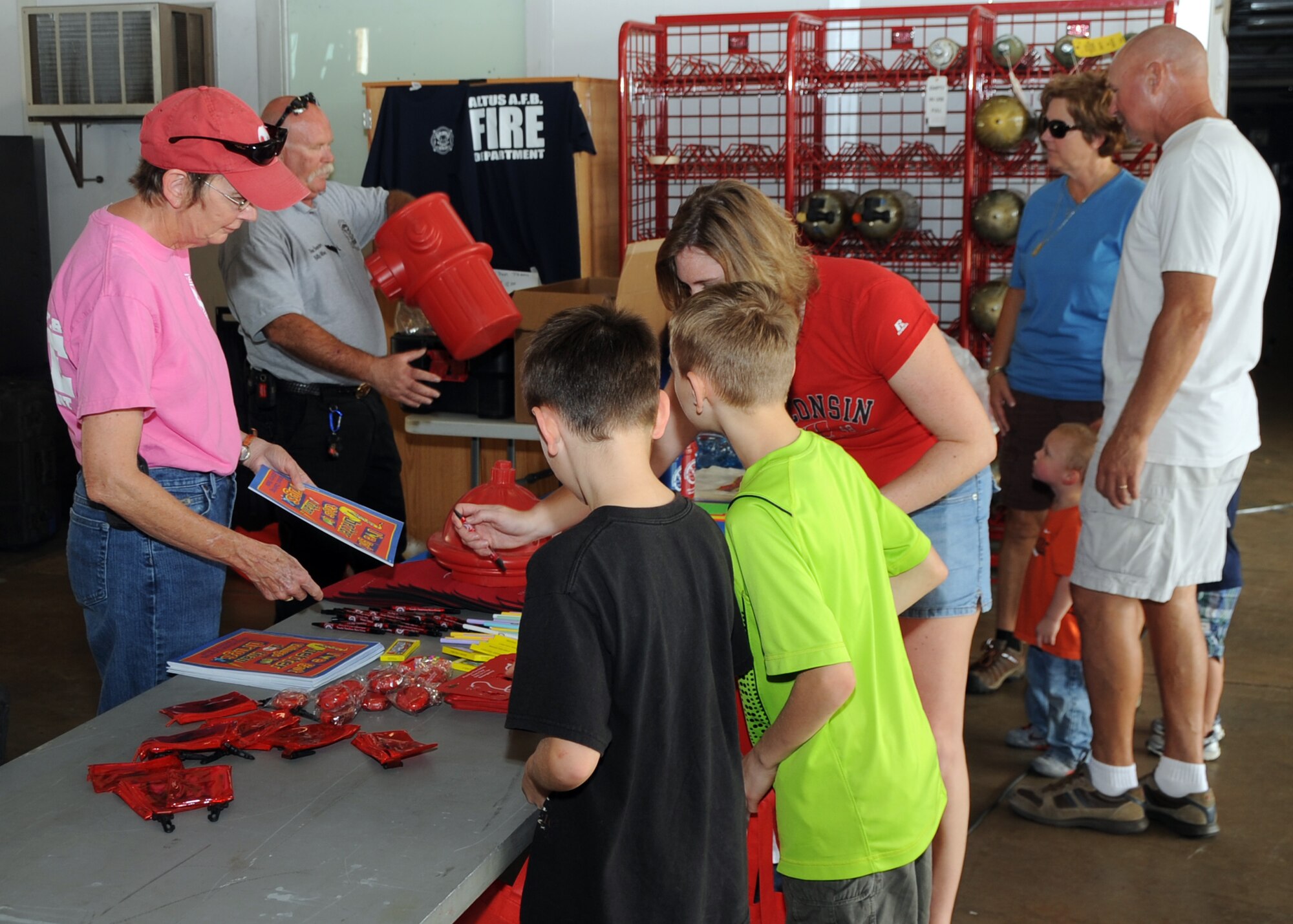 ALTUS AIR FORCE BASE, Okla. – Meltri Allday, spouse of Billy Allday, 97th Civil Engineer Squadron fire inspector, hands out supplies to children during the 97th CES fire department open house at the base fire department, Oct. 13, 2012. The base fire department held an open house to educate children about fire safety. (U.S. Air Force photo by Airman 1st Class Franklin R. Ramos / Released)
