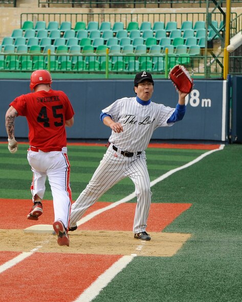 Staff Sgt. Kyle Sweiderk, 8th Operations Support Squadron, runs to first base as a member of the local Gunsan team ‘The Law’ reaches to catch the ball at Gunsan City Sports Stadium, Republic of Korea, Oct. 13, 2012. The game helped build camaraderie between the USAF and Gunsan citizens. (U.S. Air Force photo/Senior Airman Marcus Morris)