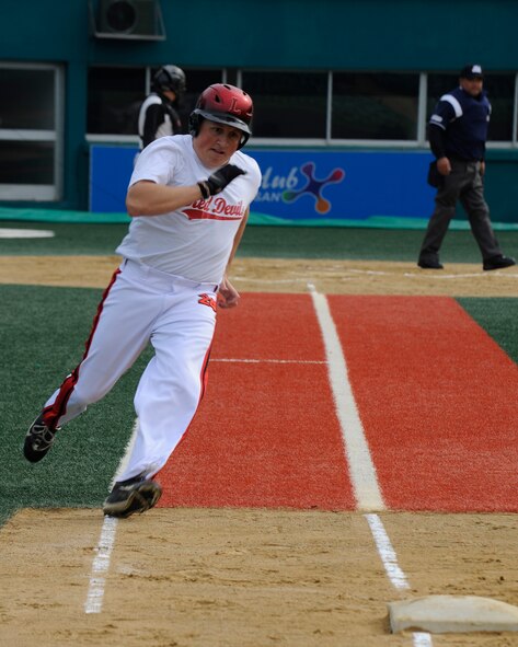 Staff Sgt. Jared Lott, 8th Civil Engineer Squadron, rounds first base  during a game between service members from Kunsan Air Base, Republic of Korea and a local Gunsan team named ‘The Law’ at Gunsan City Sports Stadium, Republic of Korea, Oct. 13, 2012. Lott ended the game hitting three triple and two doubles, assisting his teammates to score and win. (U.S. Air Force photo/Senior Airman Marcus Morris)