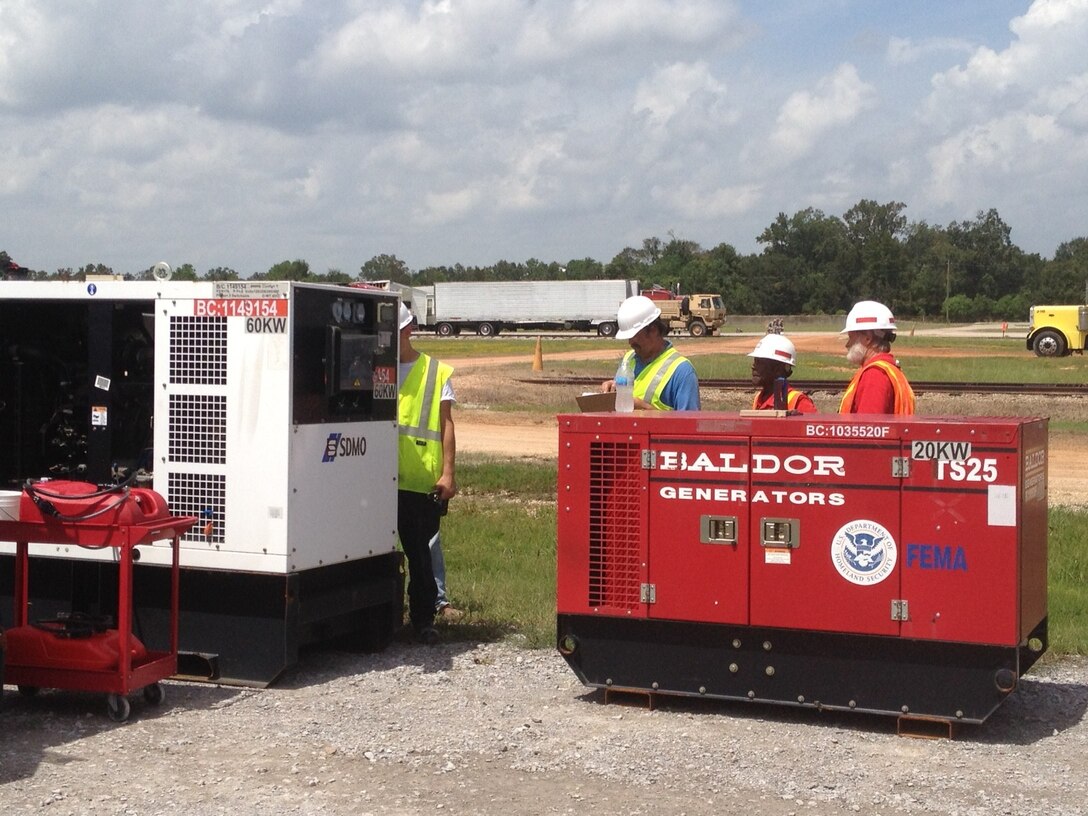 Left to right, a power contractor representative, Arthur Miller and Jack Wilkerson prepare 20 and 60 kilowatt emergency generators for return to storage as the emergency power mission ramps down.