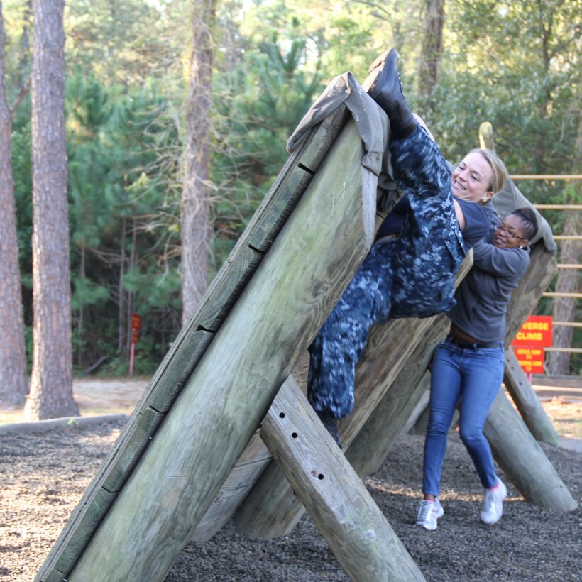 From left, Navy Lt. Jessica Snyder, audiologist,  and Celene Moorer, assistive technologist, of the National Intrepid Center of Excellence in Bethesda, Md., attempt to catapult themselves over an obstacle course apparatus during their day of boot camp at Parris Island. DOD photo by Terri Moon Cronk