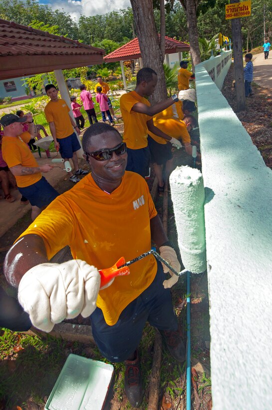 U.S. Navy Petty Officer 1st Class Farron Summerville helps paint the wall that surrounds the Baan Klong Sai school during a community service project in Phuket, Thailand, Oct. 10, 2012. Summerville, a sonar technician, is assigned to the USS Mobile Bay.