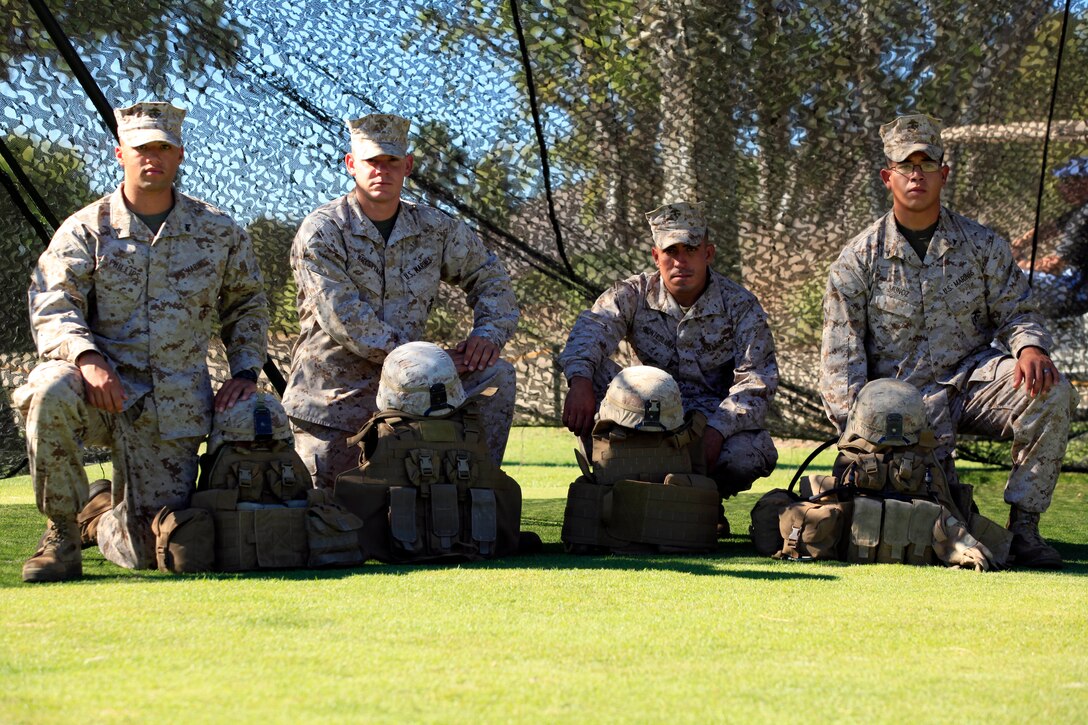 Marines from Second Battalion, Fourth Marine Regiment, Fox Company, take a group photograph with a static display of flak jackets and Kevlar helmets during the Commanding General’s 1st Invitational Golf Tournament at Camp Pendleton’s Marine Memorial Golf Course, Oct. 15.