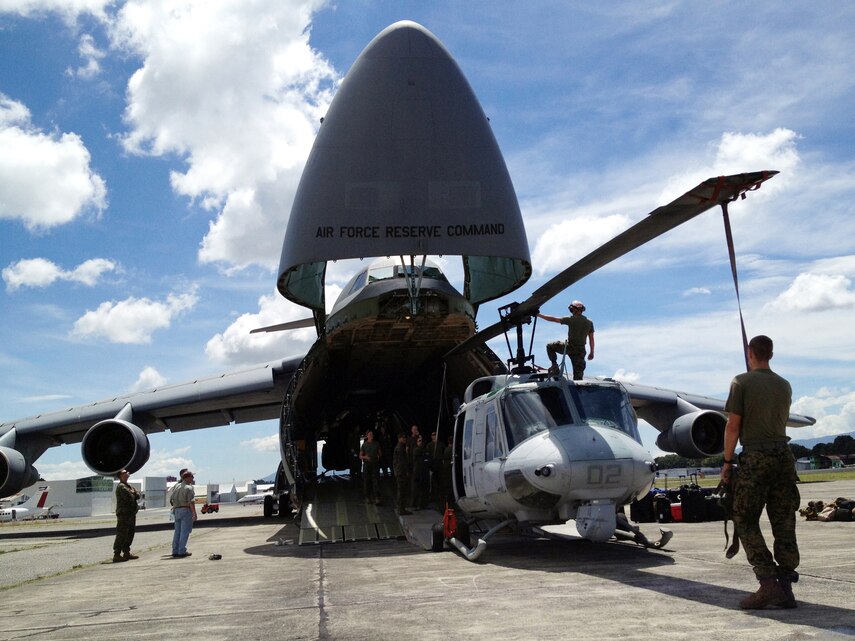 U.S. Marines with Detachment Martillo load a UH-1N "Huey" helicopter on an Air Force C-5 "Galaxy" at La Aurora International Airport in Guatemala City Oct. 12, en route back to the United States.  The task-organized detachment partnered with Guatemala authorities to disrupt illicit trafficking in the country’s coastal waters. With four Huey’s, Detachment Martillo flew over 250 detection and monitoring missions in support of Guatemalan law enforcement agencies and naval forces during the roughly two-month deployment.  "We saw an immediate impact in trafficking patterns along established routes after we started flying our helos," said Col. Rob Rauenhorst, the Detachment Martillo officer-in-charge.