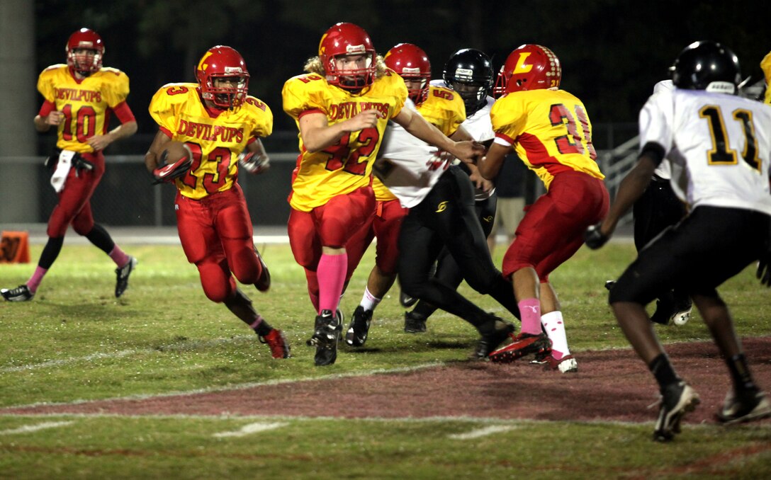 Lejeune High School’s running back Jamaz Richardson runs the ball to the outside as fullback Stephen Dicenso looks for a defensive player to block against the Pamlico County High School Hurricanes during Lejeune High’s homecoming game aboard Marine Corps Base Camp Lejeune Friday. Lejeune High School was able to effectively run the ball throughout the game, as Richardson rushed for 260 yards and three touchdowns. (Official Marine Corps photo by Lance Cpl. Scott W. Whiting) 