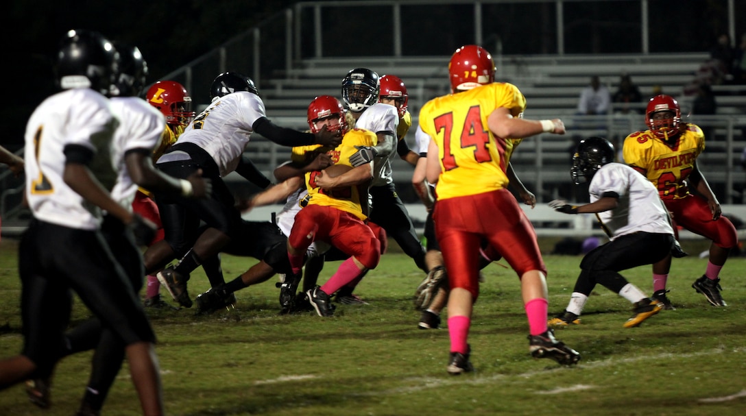 Stephen DiCenso, fullback for the Lejeune High School Devil Pups, gets tackled by three Pamlico County High School defenders after running the ball during the Devil Pups homecoming game Friday. The Devil Pups, as a team, rushed for 370 yards during the game, and DiCenso scored a touchdown along with 53 yards on the ground. (Official Marine Corps photo by Lance Cpl. Scott W. Whiting