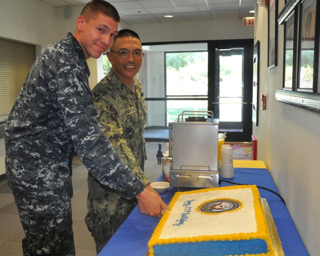 LCDR. Raymond Oviedo and RPSN Barry Menges, the oldest and youngest sailors aboard Marine Corps Logistics Base Barstow, Calif., make the first cut in the birthday cake for the United States Navy's 237th birthday cake-cutting ceremony, Oct.12, in the vase headquarters building.