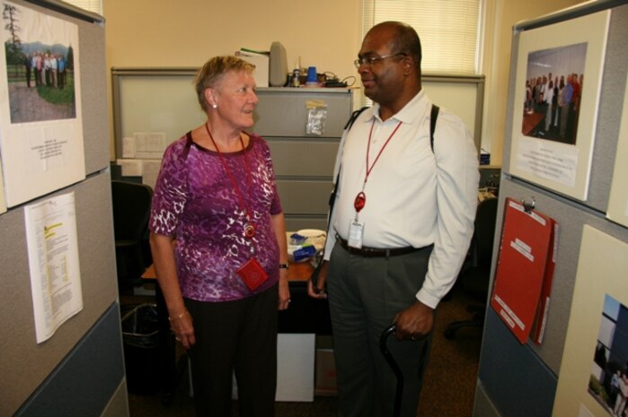 Larry Hubbard (right) discusses a Optics and Non-Lethal Systems project with colleague Germa Batton. Both are attached to Marine Corps Systems Command’s (MCSC) Infantry Weapons Systems (IWS) program management office. 