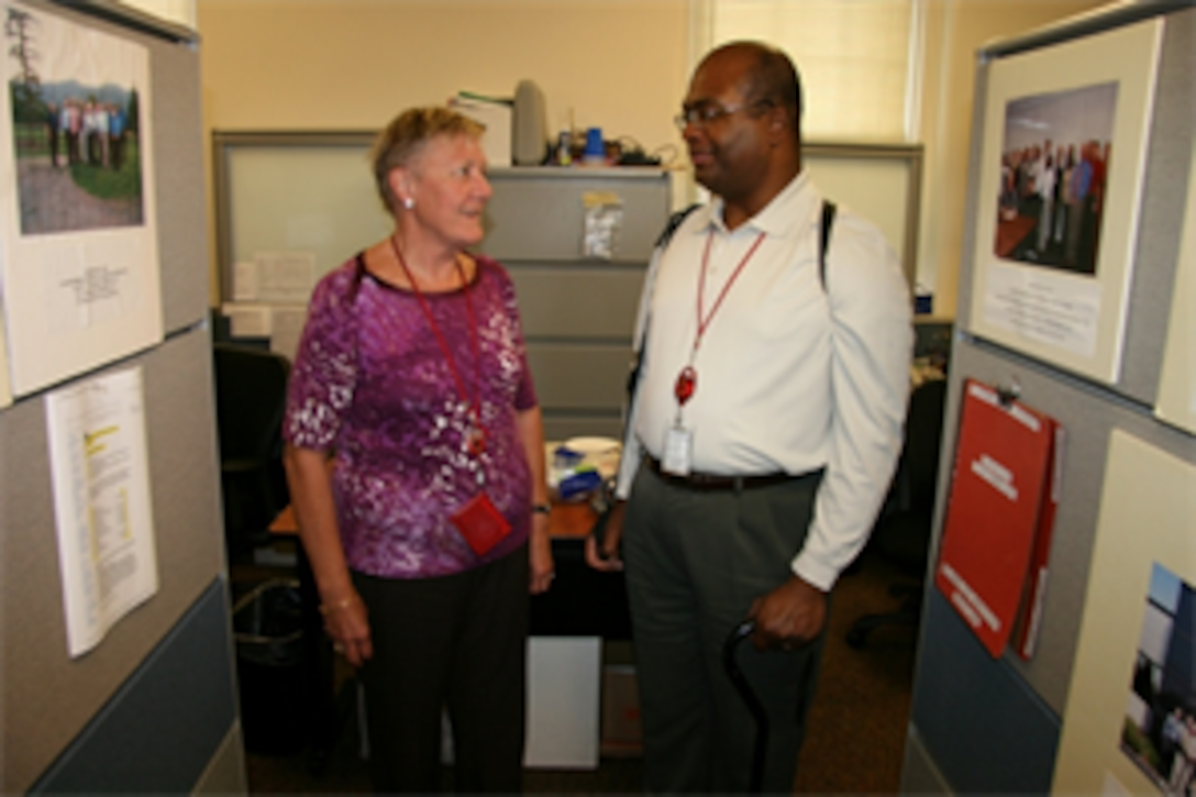 Larry Hubbard (right) discusses a Optics and Non-Lethal Systems project with colleague Germa Batton. Both are attached to Marine Corps Systems Command’s (MCSC) Infantry Weapons Systems (IWS) program management office. 