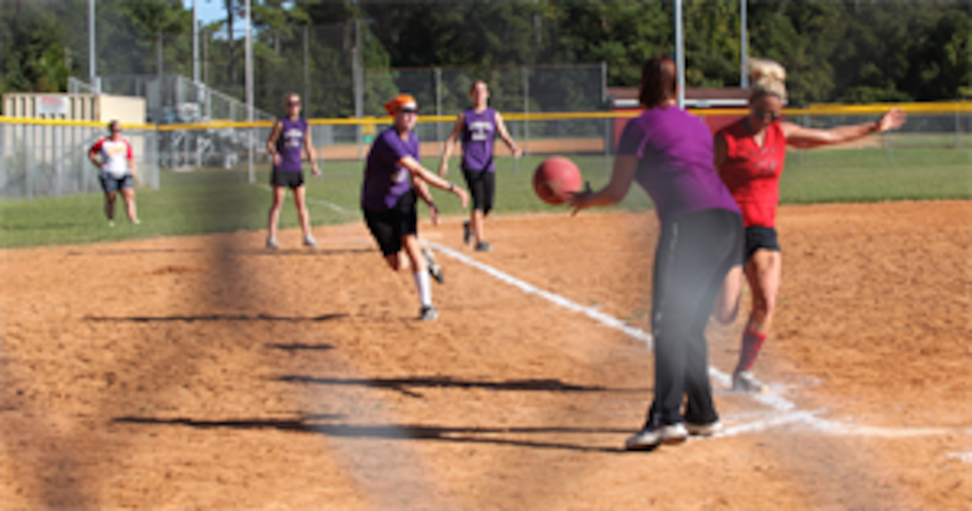 Players from the Lejeunatics try to tag a player out from the opposing team, the Lady Raiders. Spouses of Marines and sailors competed in the Spouses Lejeune Area Kickball Association or SLAKA Oct. 13-14. Most of the spouses were wives of Marines and sailors aboard Camp Lejeune, but husbands and spouses from other commands could also share in the camaraderie.