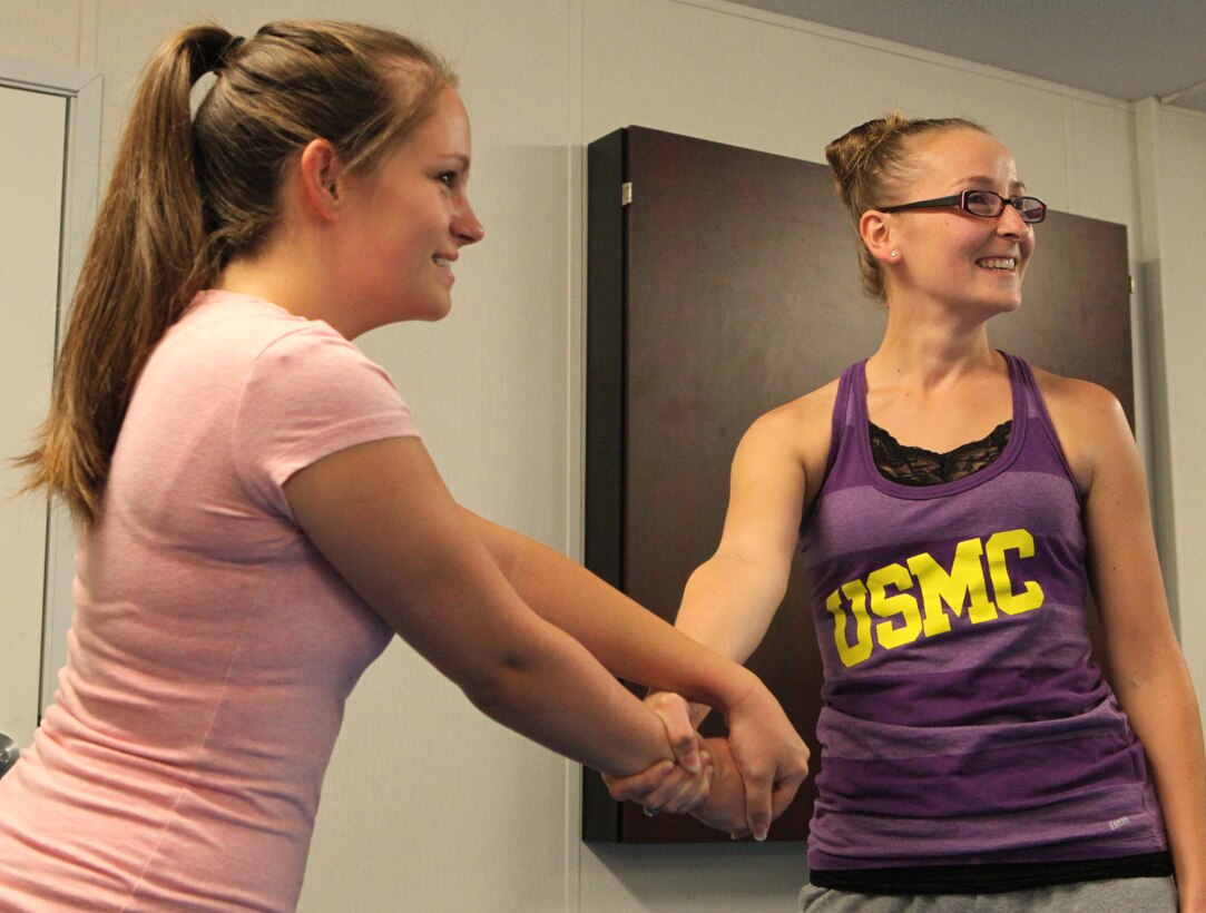 Students are all smiles as they practice how to escape a wrist hold during Marine Corps Family Team Building's Self-Defense 101 Oct. 3. A local martial arts instructor and former service member taught the class to a group of service members and military spouses. 