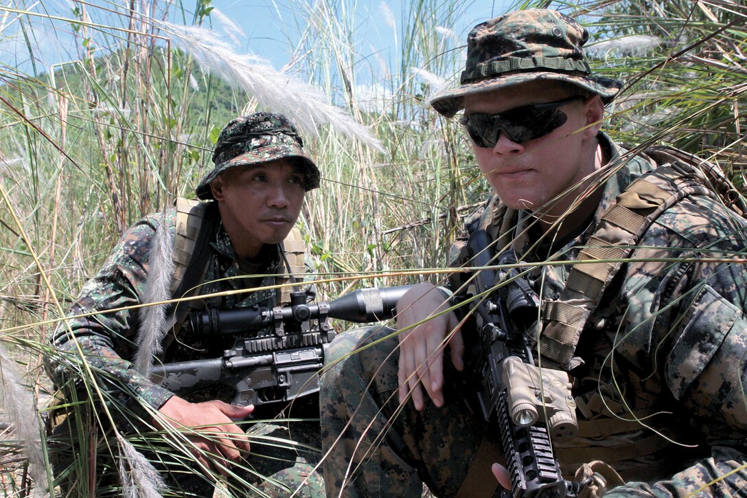 Completely surrounded by natural Philippine vegetation, Cpl. Jeremy Russow, right, crouches beside a Philippine Marine while constructing a hide site at Crow Valley, Republic of the Philippines, Oct. 9. Russow is an assistant team leader with scout sniper platoon, Battalion Landing Team 2nd Battalion, 1st Marine Regiment, 31st Marine Expeditionary Unit, III Marine Expeditionary Force. The Philippine Marine is with special operations platoon, 3rd Battalion, Philippine Marine Corps.