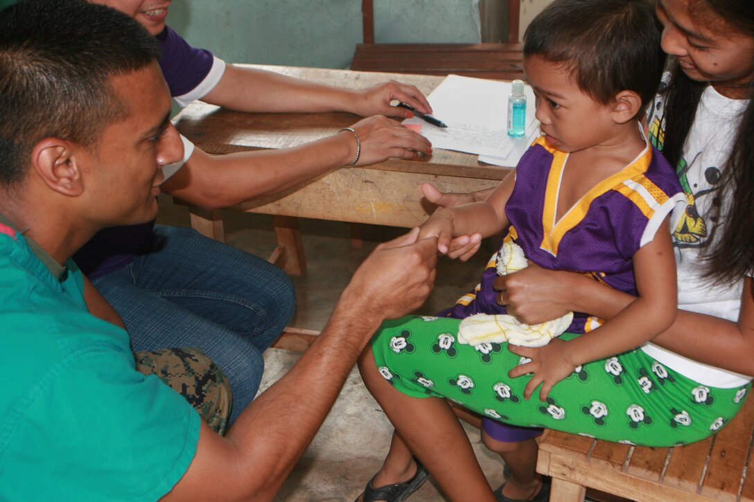 Lt. Ankush K. Jain works with patients at a medical civil affairs project during the Philippine Bilateral Amphibious Landing Exercise 2013 here, Oct. 10. PHIBLEX 2013 is a bilateral training exercise hosted annually in the Republic of the Philippines to enhance interoperability and readiness of Armed Forces of the Philippines and U.S. Forces. The training is designed to prepare both countries’ military forces for humanitarian service missions as well as strengthen bilateral ties. The civil-military component of this exercise promotes engineer and medical operational readiness while providing services to local areas. Jain is a surgeon with the 31st Marine Expeditionary Unit. 