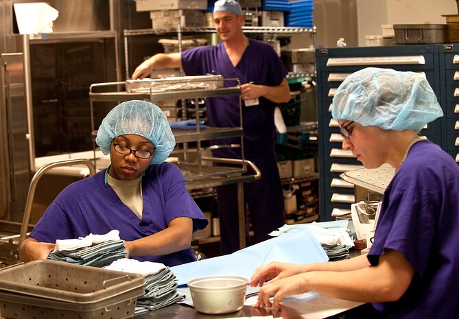 Airman 1st Class Keya Harris and Airman Melanie Signor, both 99th Surgical Operations Squadron surgical technicians, assemble surgical instrumentation as Senior Airman Andrew Merrell, 99th MSGS surgical technician unloads clean instruments from a washer decontaminator at the Mike O' Callaghan Federal Hospital Oct. 11, 2012, at Nellis Air Force Base, Nev. Surgical technicians assist surgeons during operations and sterilize the tools to help with anesthesia. (U.S. Air Force photo by Staff Sgt. Christopher Hubenthal)