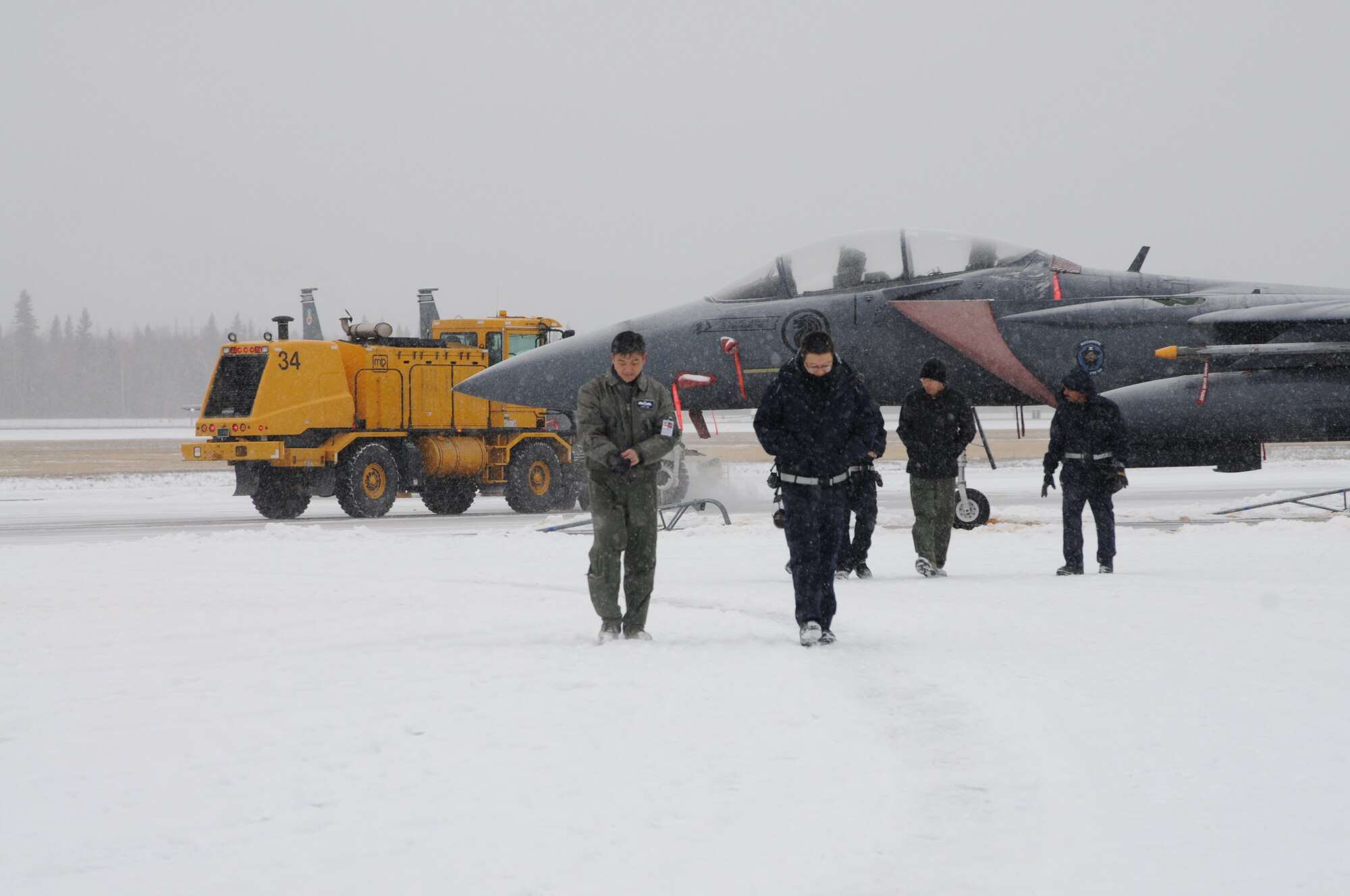 Personnel from the 428th Fighter Squadron leave the flight line at Eielson Air Force Base, Alaska, Oct. 16, 2012, after bad weather caused all aircraft to be grounded. The "Buccaneers" from Mountain Home Air Force Base, Idaho, are in Alaska participating in the RED FLAG-Alaska 13-1 exercise. (U.S. Air Force photo/Senior Airman Benjamin Sutton/Released) 