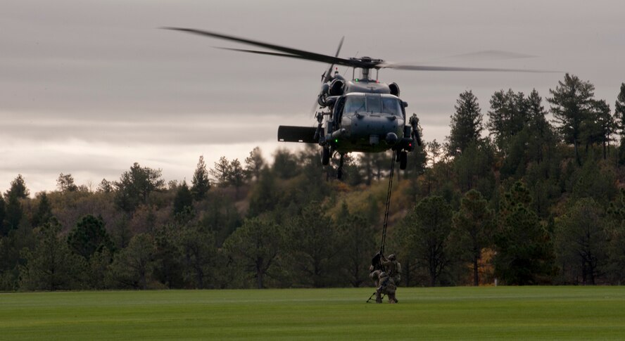 Airmen from the 563d Rescue Group climb into an HH-60G Pave Hawk after rescuing a downed pilot and fighting off an aggressor during personnel recovery training at the U.S. Air Force Academy, Colo., Oct. 4, 2012. The demonstration included a tactical insertion by the rescue team, aerial support and an extraction of a downed pilot. (U.S. Air Force photo by Senior Airman Nicholas Benroth/Released)