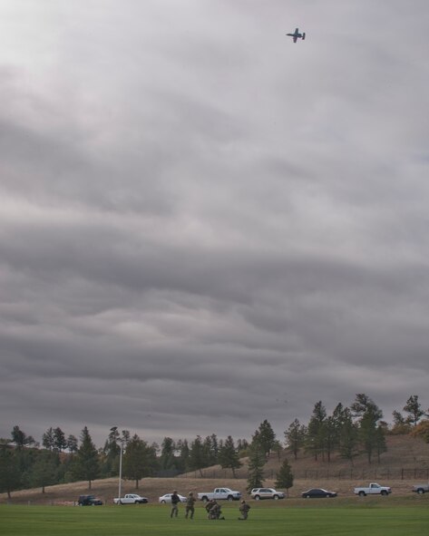 An A-10C Thunderbolt II soars overhead as pararescuemen secure the area during personnel recovery training at the U.S. Air Force Academy, Colo., Oct. 4, 2012. After securing the area, the pararescuemen trained to extract a downed pilot in preparation for a personnel recovery demonstration. (U.S. Air Force photo by Senior Airman Nicholas Benroth/Released)