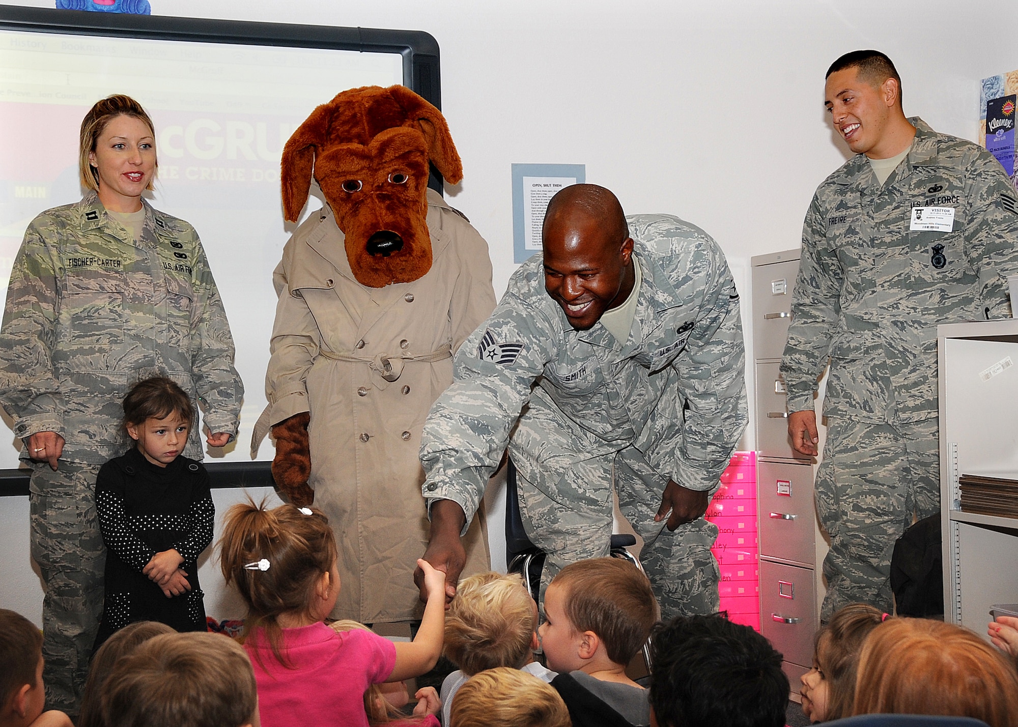 SSgt Brian Smith of the 21st Security Forces Squadron, Peterson AFB,
introduces himself by shaking hands with a preschool student at Woodment
Hills Elementary School on Oct. 11 before he explains the dangers of
speaking with strangers.  With SSgt Smith are (L to R) Capt Tamara
Fischer-Carter of AFSPC Public Affairs, Scruff McGruff the Crime Fighting
Dog, and SSgt Andres Freire of the 21st SFS.  (U.S. Air Force photo/ Duncan Wood)
  
