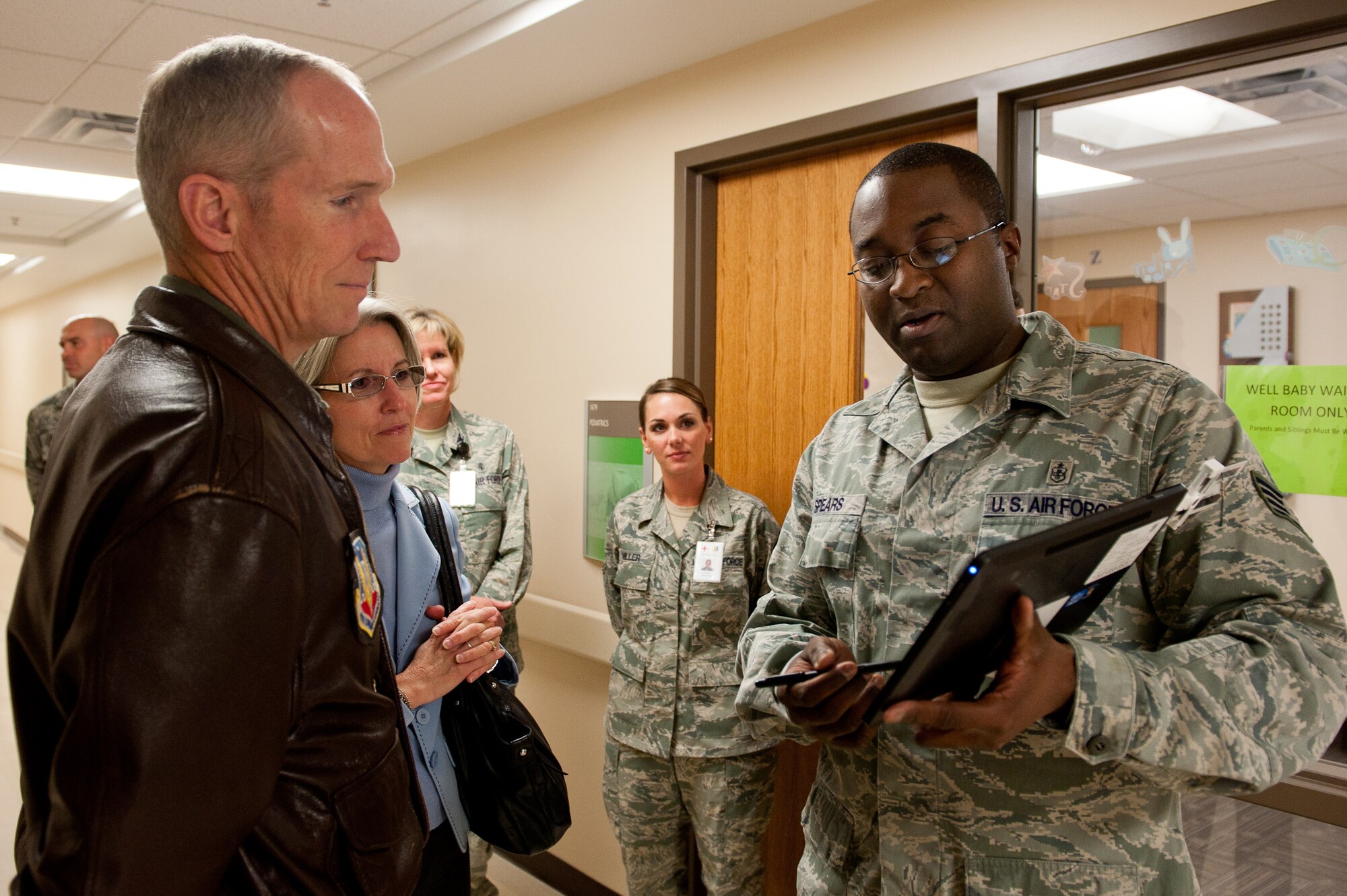 Air Force Staff Sgt. Kevin Spears, 28th Medical Operations Squadron information systems NCO in charge, explains how the 28th Medical Group and providers use a tablet to document a patient’s care during an exam to Gen. Mike Hostage, commander of Air Combat Command, and his wife, Kathy, in the clinic at Ellsworth Air Force Base, S.D., Oct. 10, 2012. Hostage and his wife toured the facility and viewed some of its modern additions including a mobile storage device for the supply room that saves more than 30 percent in the amount of space used. (U.S. Air Force photo by Airmen 1st Class Kate Thornton-Maurer/ Released)
