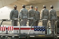 Senior Airman Joshua Fernandez, far right, serves as a member of the Air Force Mortuary Affairs Operations carry team, July 7, 2010 during his first deployment to the mortuary. Fernandez, a reservist with the 512th Memorial Affairs Squadron, is currently serving his third deployment in support of the mortuary mission. (U.S. Air Force Photo/Jason Minto)