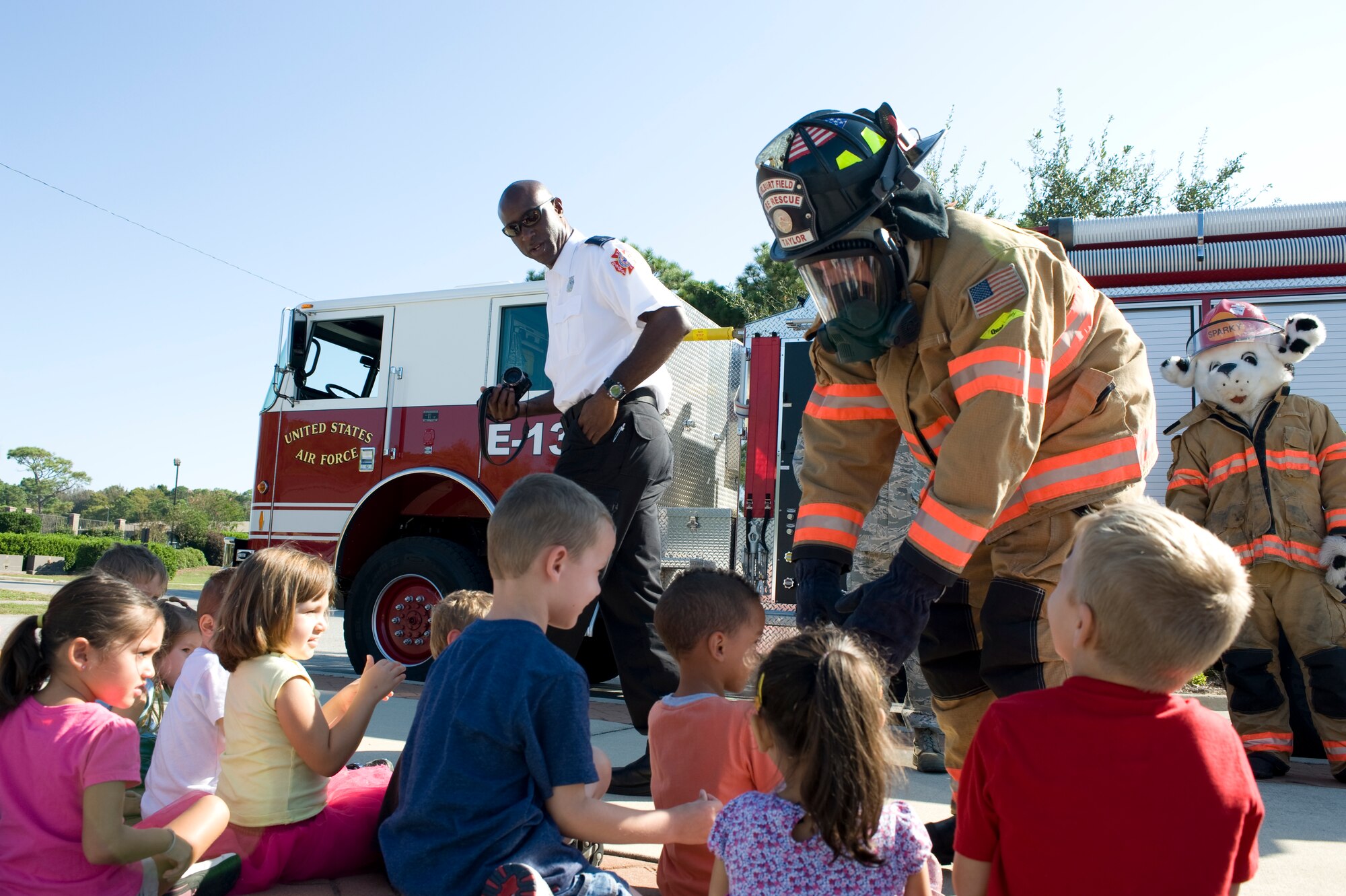 Airman 1st Class Nicholas Taylor, a firefighter of 1st Special Operations Civil Engineer Squadron, exchanges handshakes with children as part of Fire Awareness Month at the Child Development Center at Hurlburt Field, Fla., Oct. 9, 2012.  Taylor modeled the protective gear that firefighters wear to familiarize the children with whom to expect when a fire occurs.  (U.S. Air Force photo / Airman 1st Class Benjamin D. Kim)