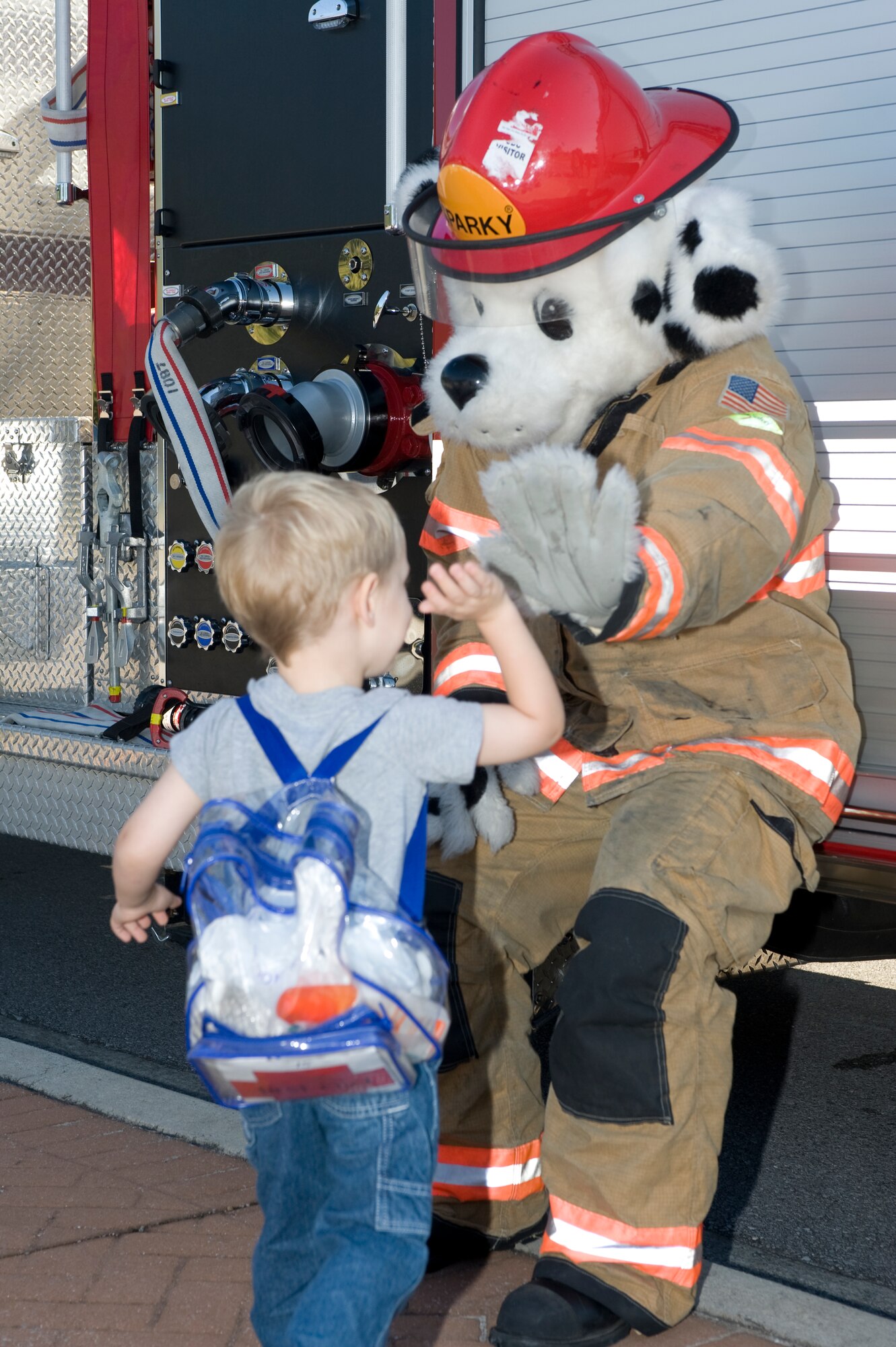 Sparky the Fire Dog hands out high-fives as part of Fire Awareness Week at the Child Development Center at Hurlburt Field, Fla., Oct. 9, 2012.  Children lined up and gave Sparky the Fire Dog hugs and high-fives in an attempt to build a positive relationship with the fire department.  (U.S. Air Force photo / Airman 1st Class Benjamin D. Kim)
