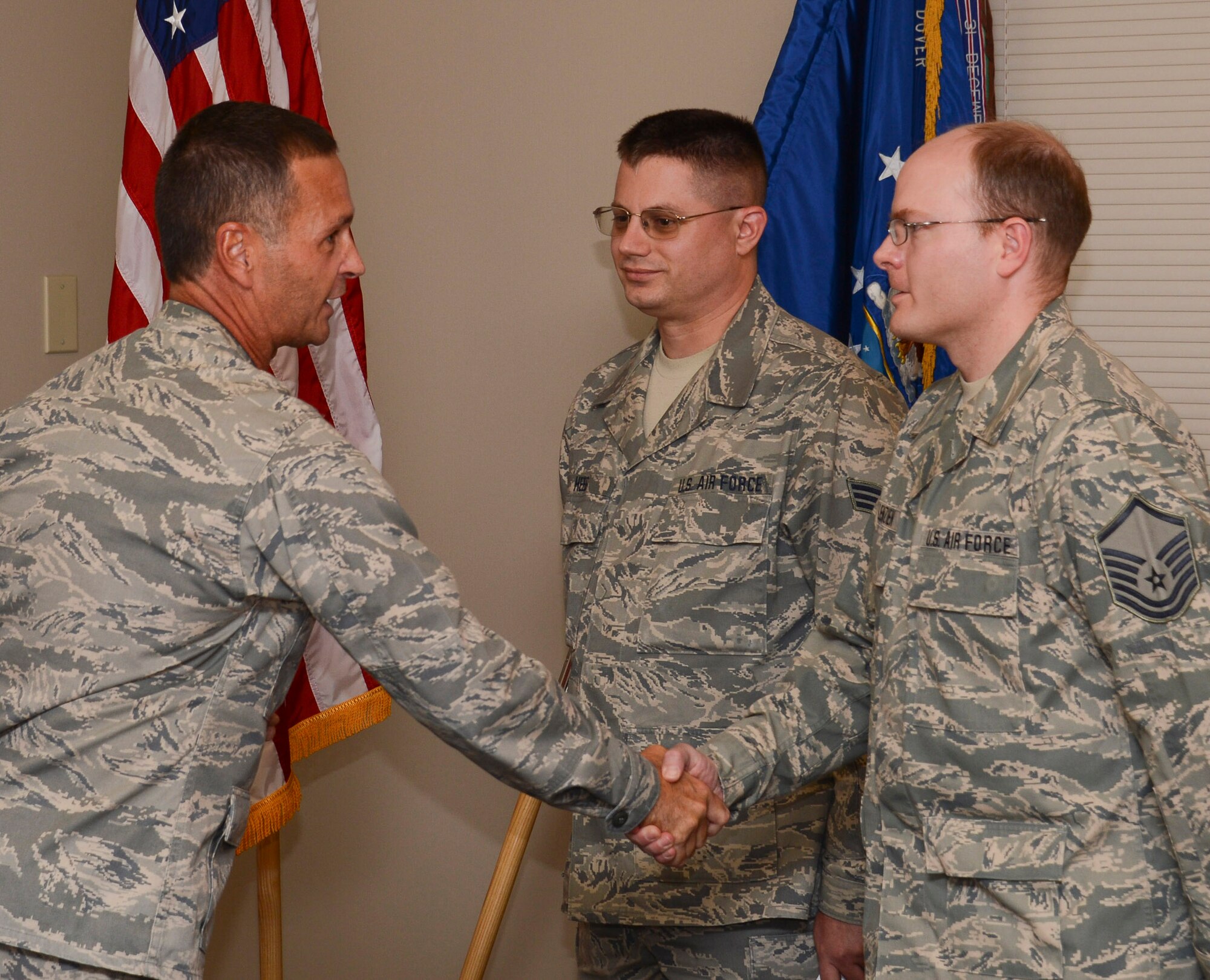 Brig. Gen. Worthe S. Holt, Jr., (left) the Assistant Adjutant General-Air for the Minnesota National Guard congratulates Senior Airman Gunther Heeb, (center) 133rd Operations Support Flight and Master Sgt. Michael Wollenzien, 133rd Communications Flight as they join the Kentucky Air National Guard Oct. 13, 2012 during a ceremony at the St. Paul Air National Guard base. The Airmen are in a program where they are members of the 223rd Intelligence Flight, based in Louisville, Ky., but will remain working in Minnesota. photo by Tech. Sgt. Erik Gudmundson/released