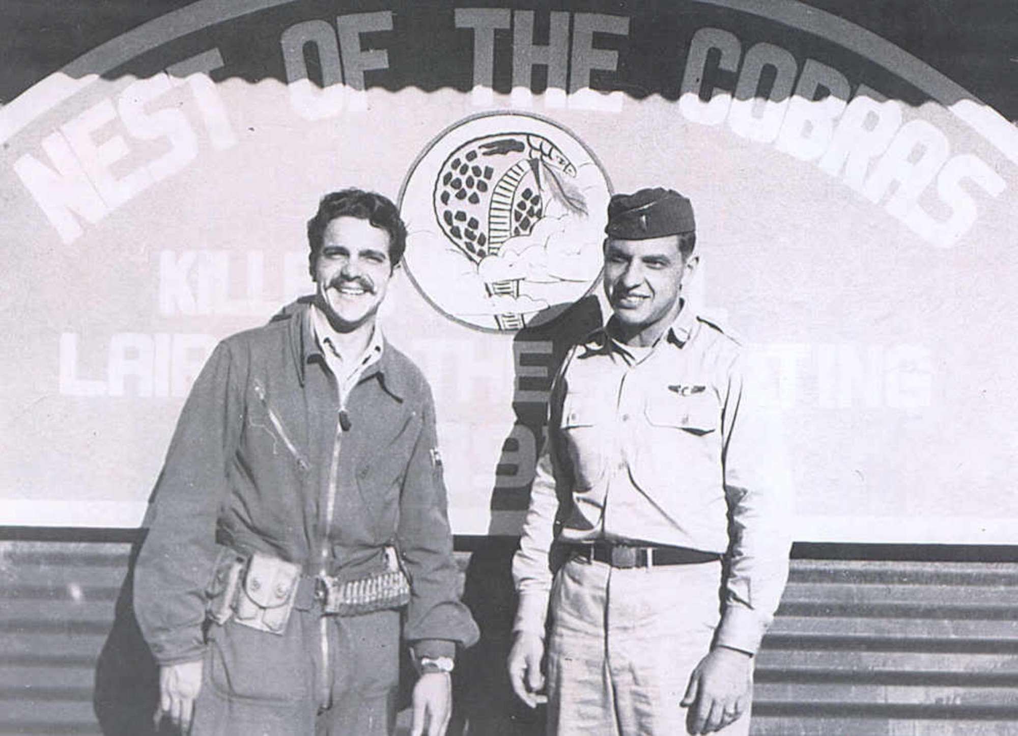 John Taylor (left) and Ernest Wakehouse stand in front of the 39FIS operations shack at an airfield in the Republic of Korea, 1951.