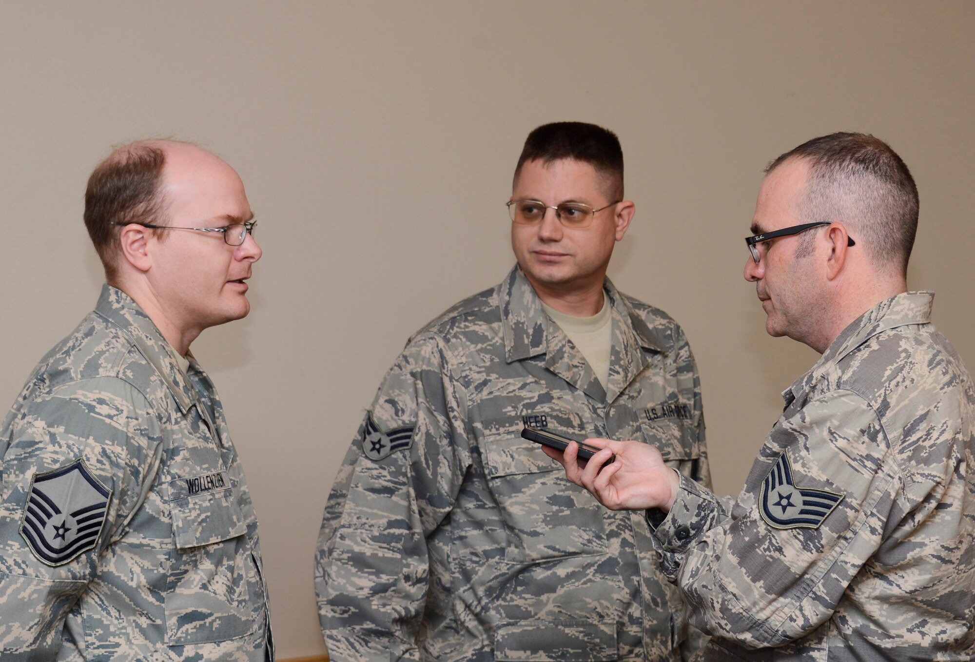 Master Sgt. Michael Wollenzien, (left) 133rd Communications Flight and Senior Airman Gunther Heeb, (center) 133rd Operations Support Flight of the Minnesota Air National Guard were sworn into the Kentucky Air National Guard Oct. 13, 2012 during a ceremony at the St. Paul Air National Guard base and were interviewed by Staff Sgt. Jonathan Young of the 133rd AW public affairs office. “The degree in which the Minnesota National Guard has demonstrated its incredible excellence across the board with its flying units and now its cyber opportunities really show that we are on the leading edge, the tip of the spear,” said Brig. Gen. Worthe S. Holt, Jr., the Assistant Adjutant General-Air for the Minnesota National Guard as he presided over the reenlistment. U.S. Air Force photo by Tech. Sgt. Erik Gudmundson/released