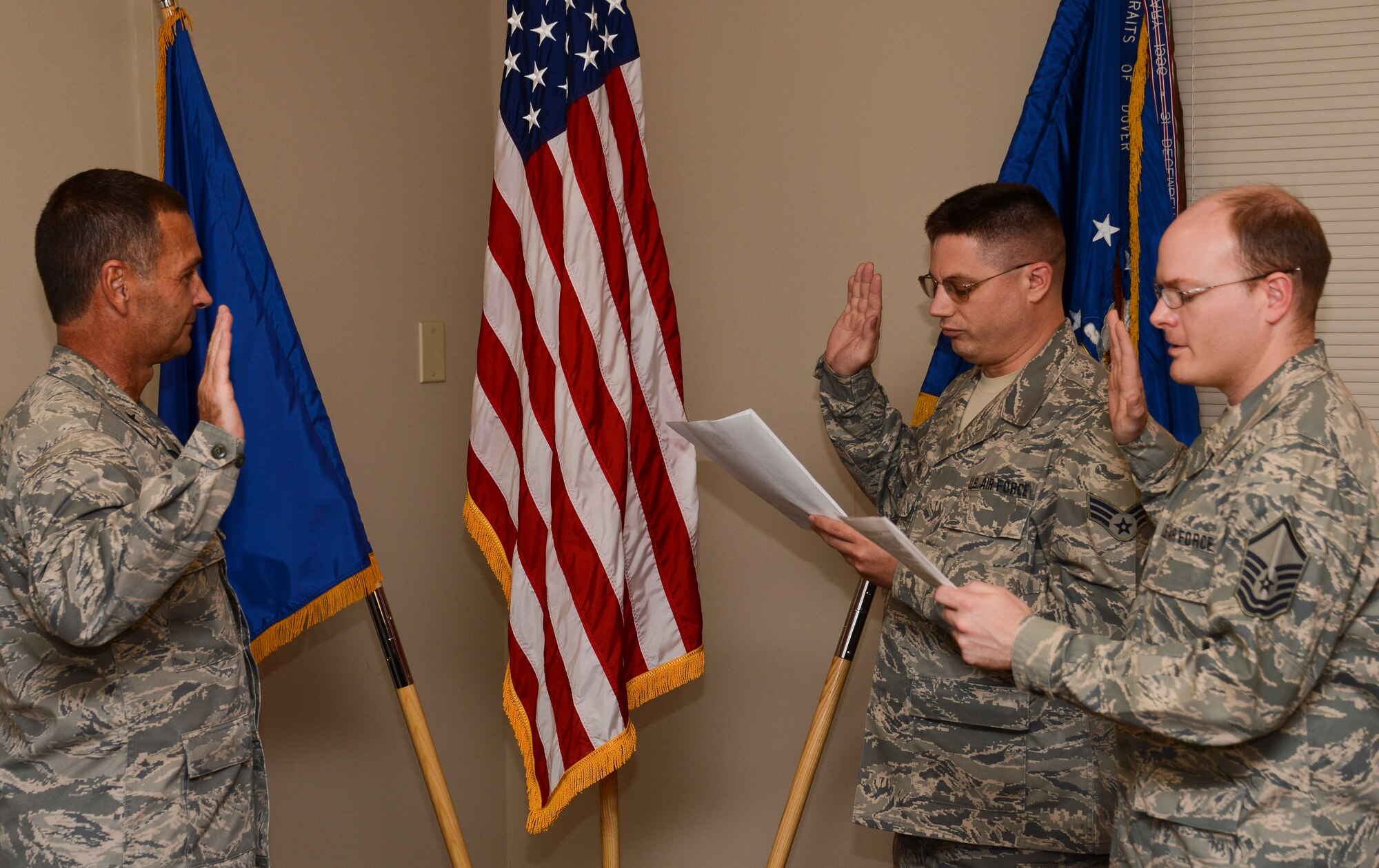 Brig. Gen. Worthe S. Holt, Jr., (left) the Assistant Adjutant General-Air for the Minnesota National Guard swears in Senior Airman Gunther Heeb, (center) 133rd Operations Support Flight and Master Sgt. Michael Wollenzien, 133rd Communications Flight into the Kentucky Air National Guard Oct. 13, 2012 during a ceremony at the St. Paul Air National Guard base. The Airmen are in a program where they are members of the 223rd Intelligence Flight, based in Louisville, Ky., but will remain working in Minnesota. photo by Tech. Sgt. Erik Gudmundson/released