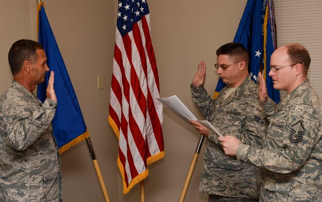 Brig. Gen. Worthe S. Holt, Jr., (left) the Assistant Adjutant General-Air for the Minnesota National Guard swears in Senior Airman Gunther Heeb, (center) 133rd Operations Support Flight and Master Sgt. Michael Wollenzien, 133rd Communications Flight into the Kentucky Air National Guard Oct. 13, 2012 during a ceremony at the St. Paul Air National Guard base. The Airmen are in a program where they are members of the 223rd Intelligence Flight, based in Louisville, Ky., but will remain working in Minnesota. photo by Tech. Sgt. Erik Gudmundson/released