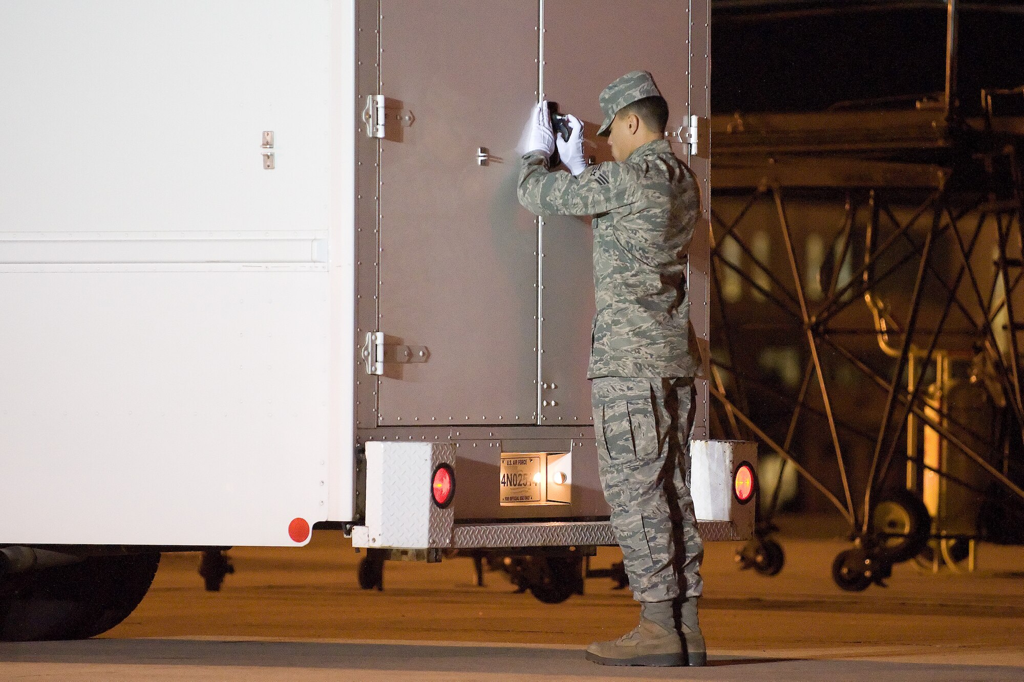 Senior Airman Joshua Fernandez closes the door of the transfer vehicle during a dignified transfer Nov. 13, 2011, at Dover Air Force Base, Del. Fernandez has served in a variety of positions inside the Charles C. Carson Center for Mortuary Affairs during his deployments in support of the sacred mission. Fernandez is assigned to the 512th Memorial Affairs Squadron at Dover AFB. (U.S. Air Force Photo/Adrian Rowan)

