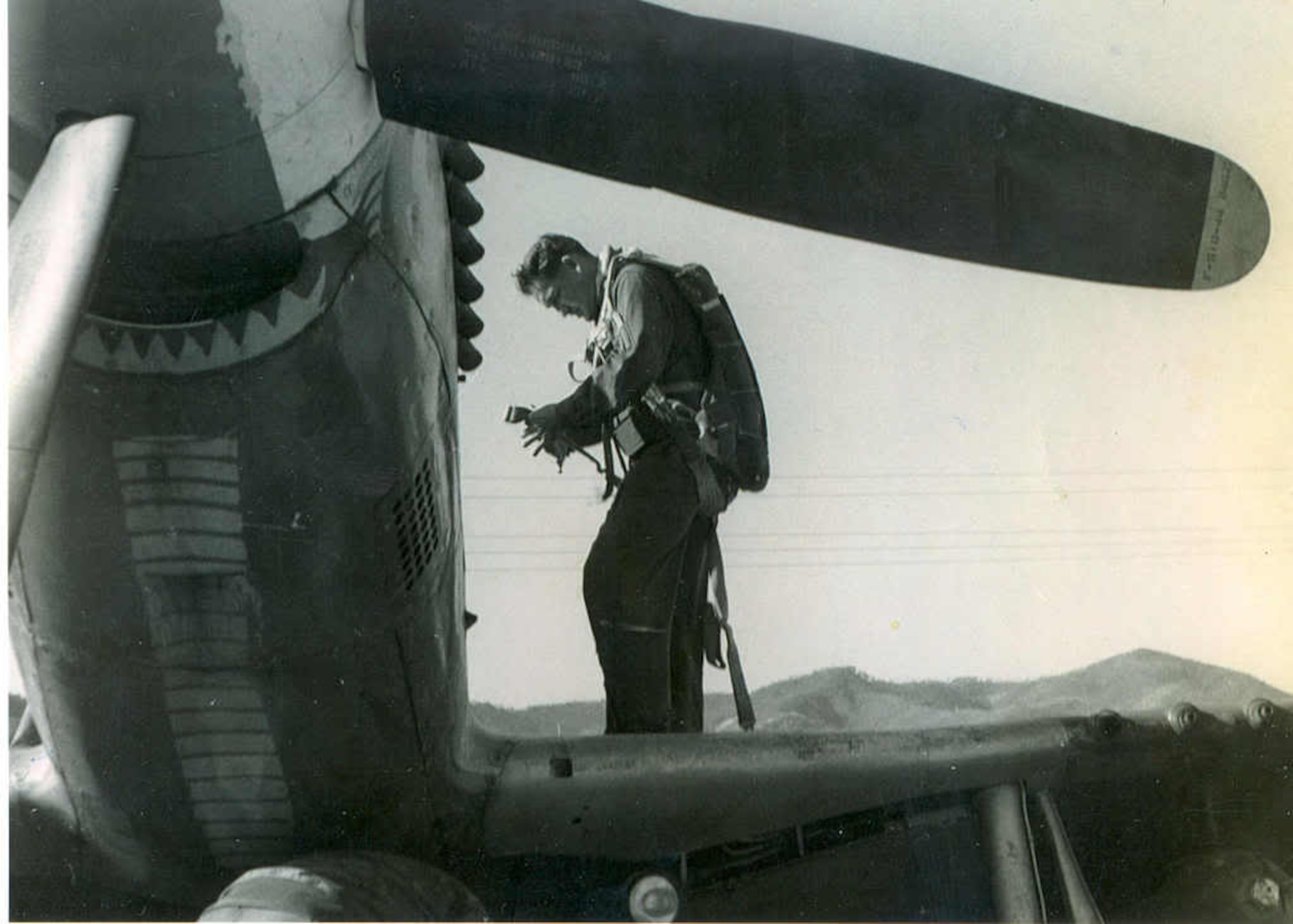 Oregon Air Guardsman Greg James prepares to embark on a combat mission in an F-51 Mustang fighter-bomber.  Note the “cobra” markings on the belly of his plane, indicating this was the aircraft of the fellow squadron member John “JET” Taylor.  An intense warrior and candidate for the ultimate fighter pilot, Taylor had a cobra, representing the 39th Fighter Interceptor Squadron, painted along the entire length of the bottom of the fuselage of his Mustang because he wanted the enemy to know who it was that killed him.  He later rose to the rank of major general and commanded the Texas ANG.