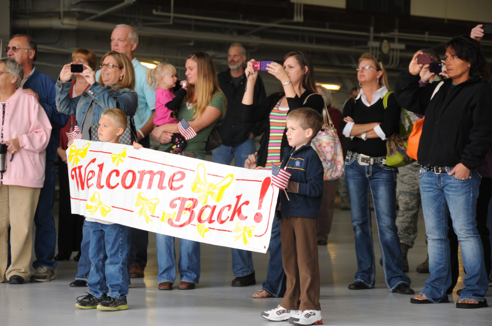 Family and friends of members of the 185th Air Refueling Wing, Security Forces Squadron, Sioux City, Iowa, await the arrival of their loved ones as they return home after a six month deployment to an undisclosed location in the South-west Theater of operations on 17 October, 2012. (US Air Force Photo by TSgt Brian Cox)