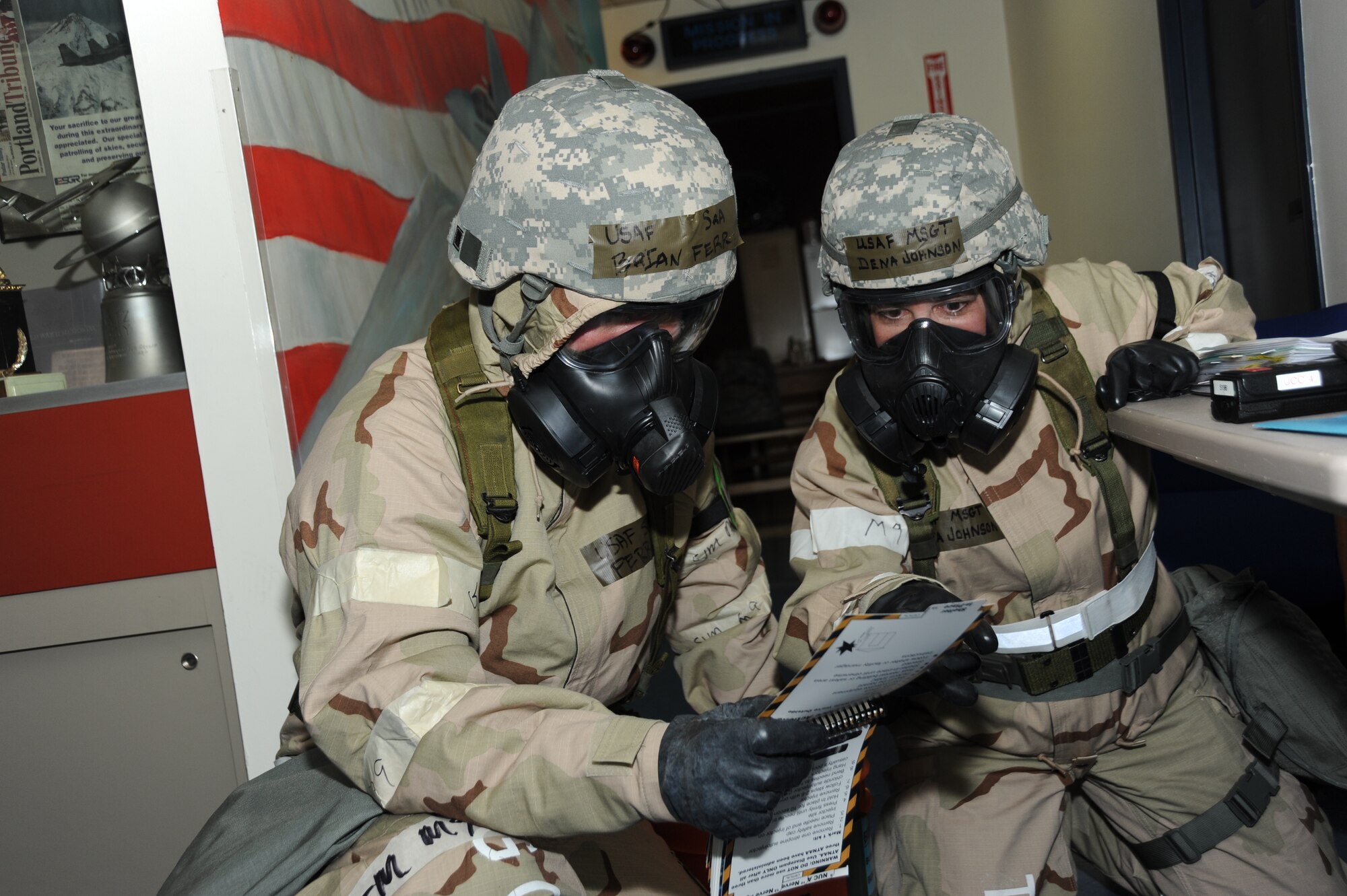 PORTLAND AIR NATIONAL GUARD BASE – Portland, Ore., Oregon Air National Guard Senior Airman Briana Ferr and Master Sgt. Dena Johnson of the 142nd Fighter Wing review their Airman’s Manual as they respond to a simulated attack during an operational readiness exercise, Oct. 13, 2012. The 142nd Fight Wing has begun training for an Operational Readiness Phase II inspection to occur in 2013.        (U.S. Photo by Tech. Sgt. John Hughel, 142nd Fighter Wing Public Affairs/Released)